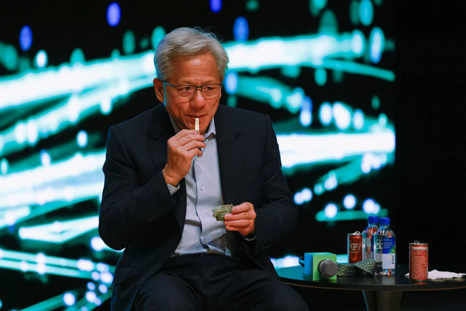 جنسن هوانغ الرئيس التنفيذي لإنفيديا يتناول وجبة خفيفة خلال مؤتمر صحافي في قمة «أبيك 2025» (رويترز)