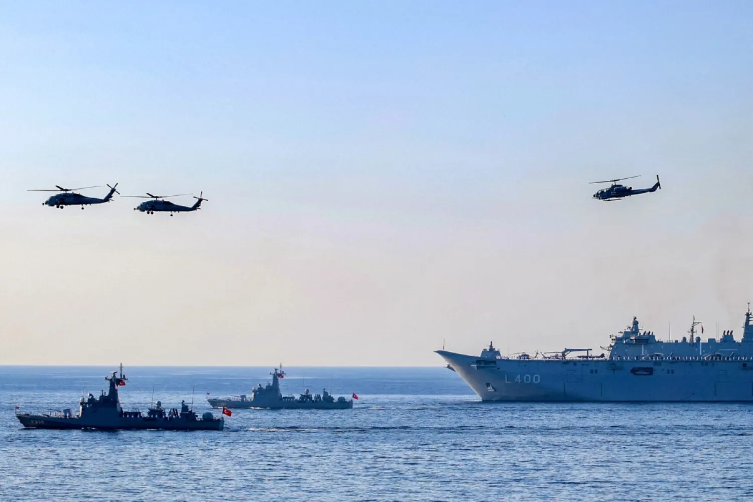 Tek taraflı deklare edilmiş Kuzey Kıbrıs Türk Cumhuriyeti'nin Girne semalarındaki Türk helikopterleri ve savaş gemileri  (AFP)
