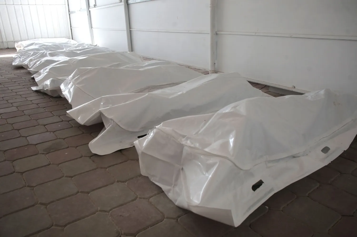 Some of the thirty body bags containing the corpses of Palestinian prisoners detained by Israel and released as part of the hostage exchange deal, are laid out in the grounds of the Nasser Medical Complex, in Khan Younis, in the southern Gaza Strip, on October 31, 2025. (AFP) 