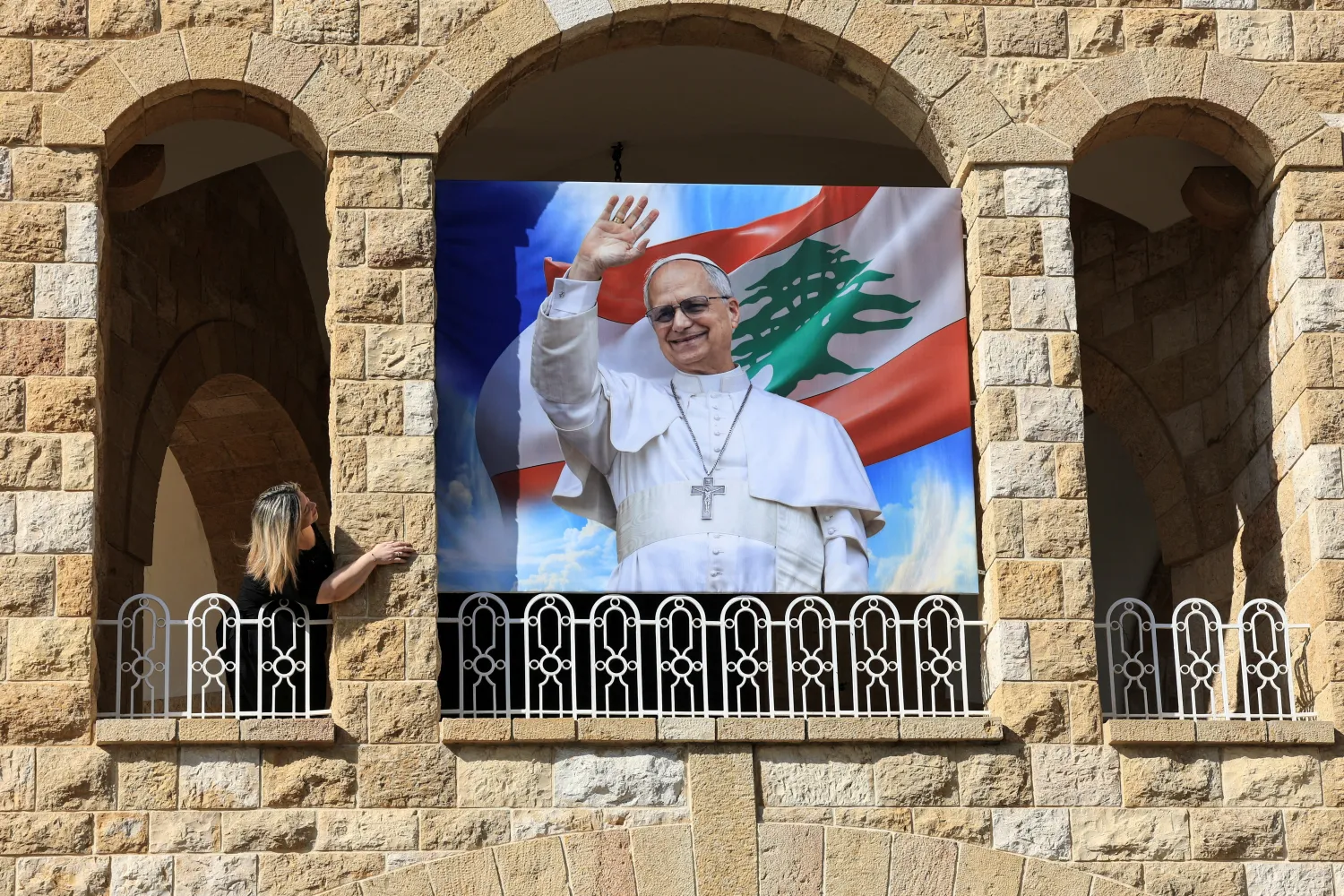 FILE PHOTO: A woman stands next to a poster depicting Pope Leo XIV at De La Croix Psychiatric Hospital in Jal el-Dib, Lebanon November 19, 2025. REUTERS/Mohamed Azakir/File Photo