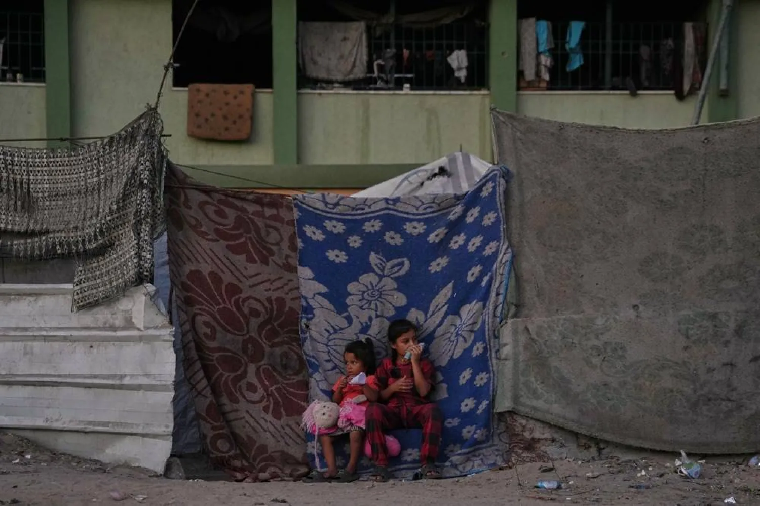 Palestinian girls sit in front of their family's tent set up in an area in Khan Younis, Friday, Oct. 31, 2025. (AP)