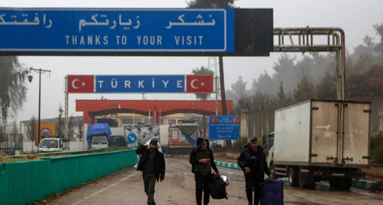 People carrying their belongings cross into to Syria from Türkiye through the Kassab crossing on Dec. 27, 2024. (AFP) 