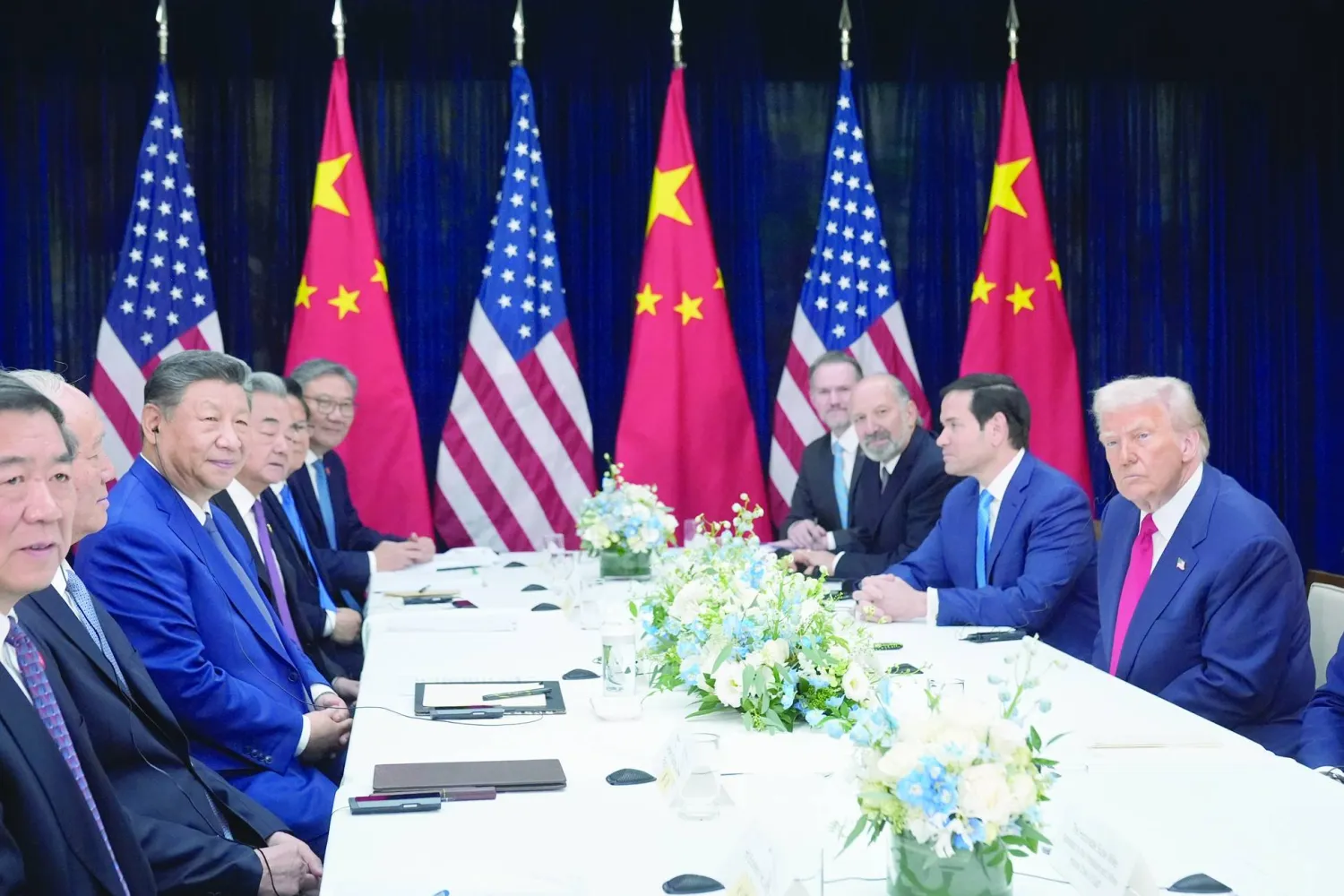 الرئيسان الأميركي دونالد ترمب والصيني شي جينبينغ مع فريقيهما خلال القمة في مطار جيمهاي بكوريا الجنوبية (أ.ب)