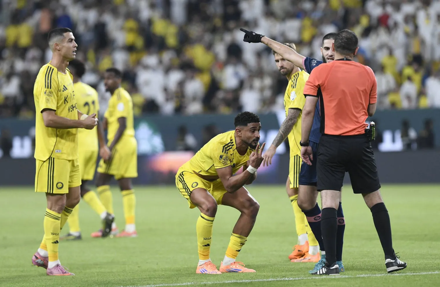 عبدالإله العمري في نقاش مع حكم المباراة الهويش قبل احتساب الجزائية (رويترز)