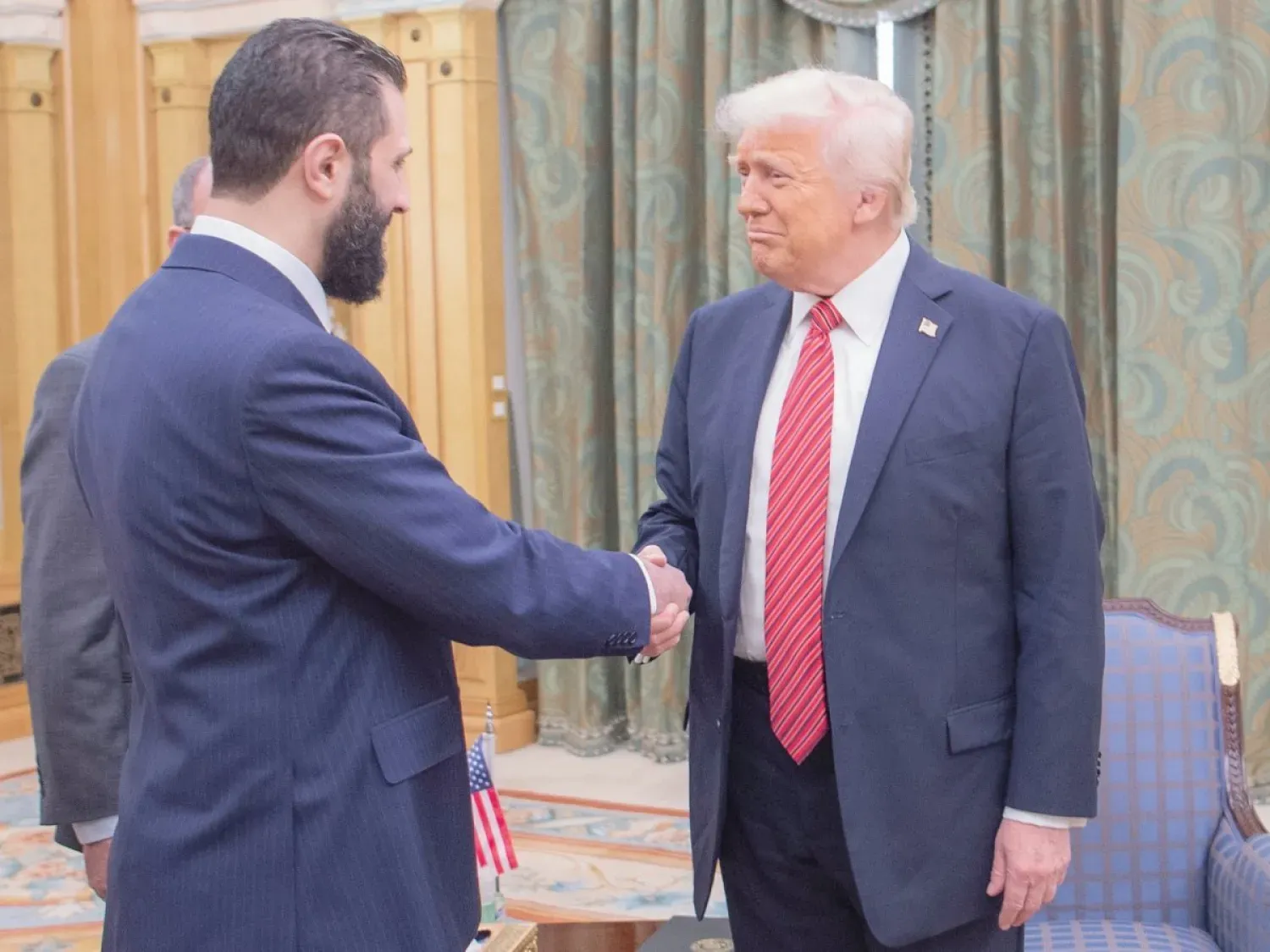 ABD Başkanı Donald Trump, 14 Mayıs'ta Riyad'da Suriye Cumhurbaşkanı Ahmed eş-Şara ile tokalaşırken (AP)