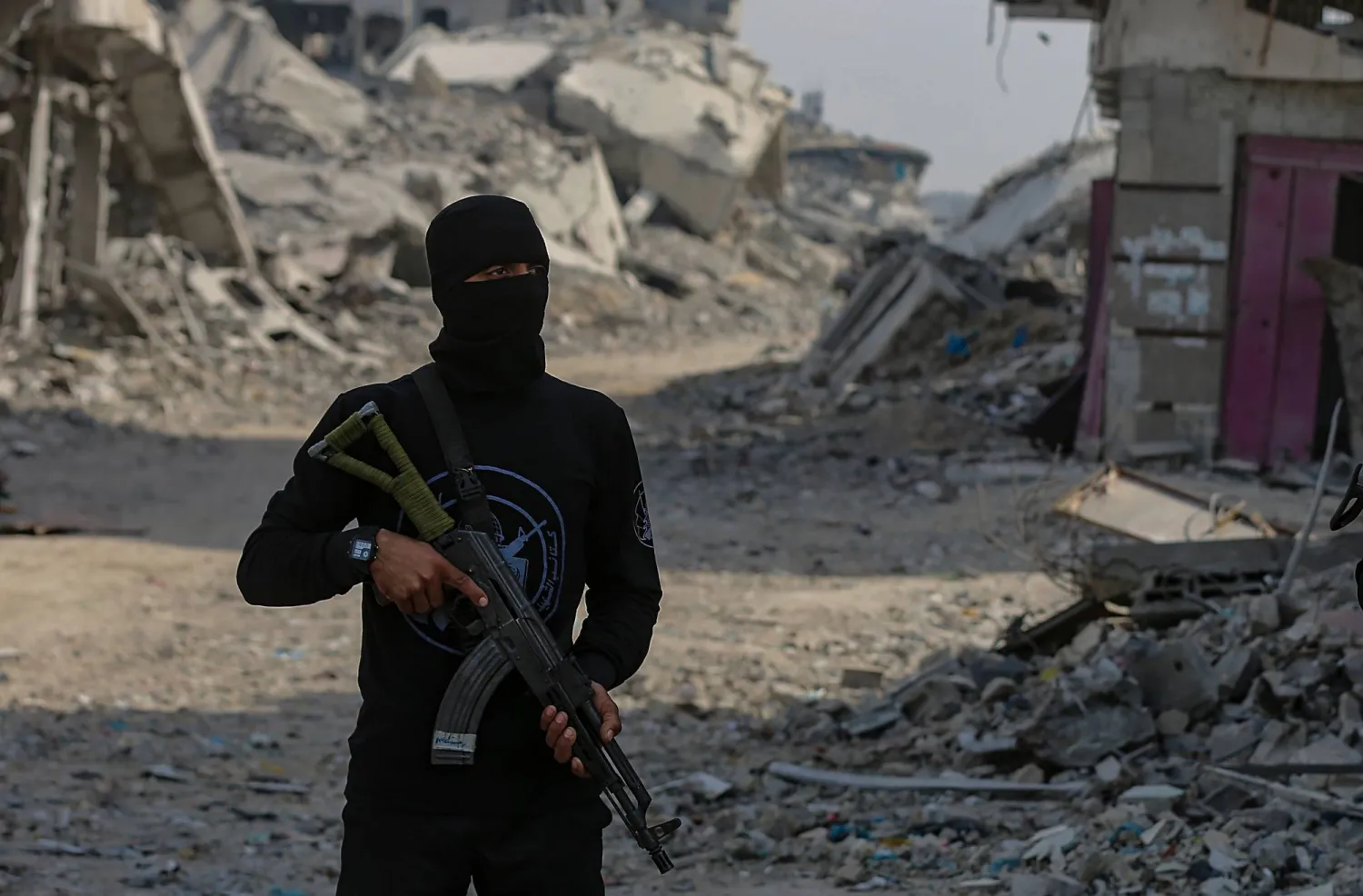 أحد عناصر «كتائب القسام» يقف قرب أحد مواقع البحث عن رفات الرهائن الإسرائيليين في قطاع غزة (إ.ب.أ)