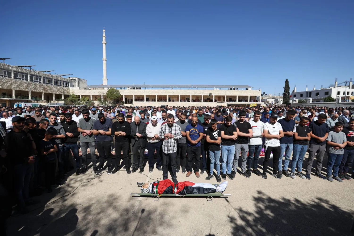 مشيعون فلسطينيون يصلون على فتى فلسطيني يبلغ من العمر 15 عاماً خلال جنازته بقرية سلواد بالقرب من مدينة رام الله في الضفة الغربية (إ.ب.أ)