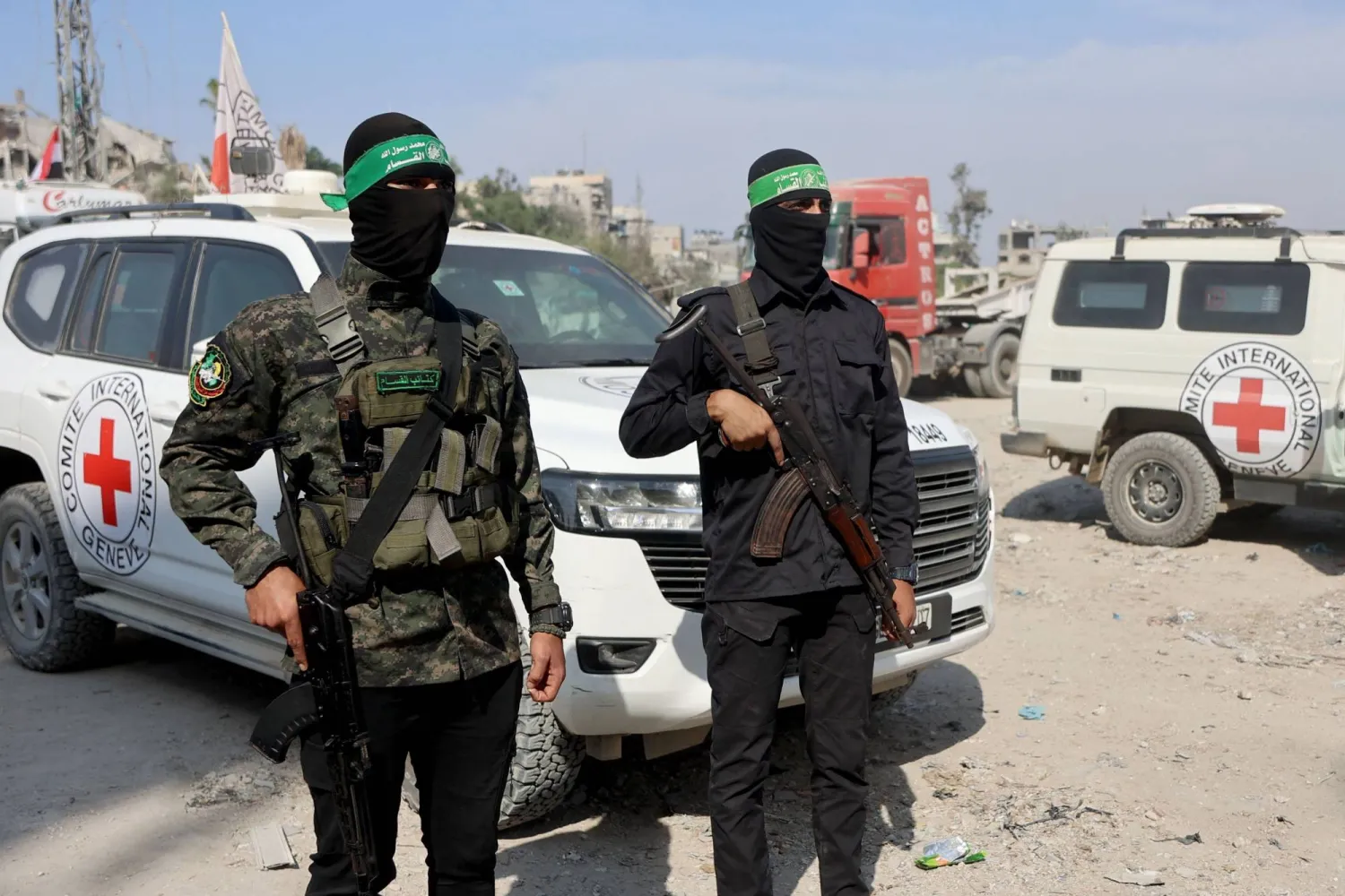 عنصران من «حماس» مع أفراد من «الصليب الأحمر» الدولي خلال استئناف عملية البحث عن جثث رهائن إسرائيليين بمدينة غزة يوم الأحد (أ.ف.ب)