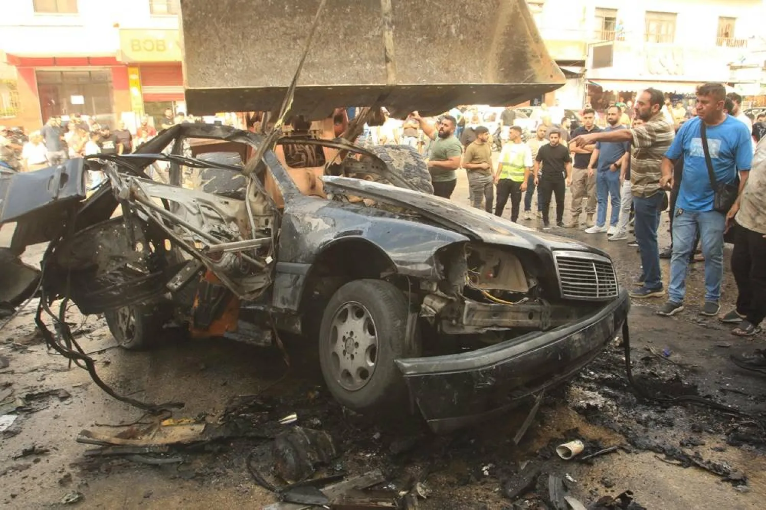 A bulldozer removes the wreckage of a vehicle targeted by an Israeli drone strike in the southern Lebanese village of Doueir, near the city of Nabatiyeh on November 3, 2025. (AFP) 