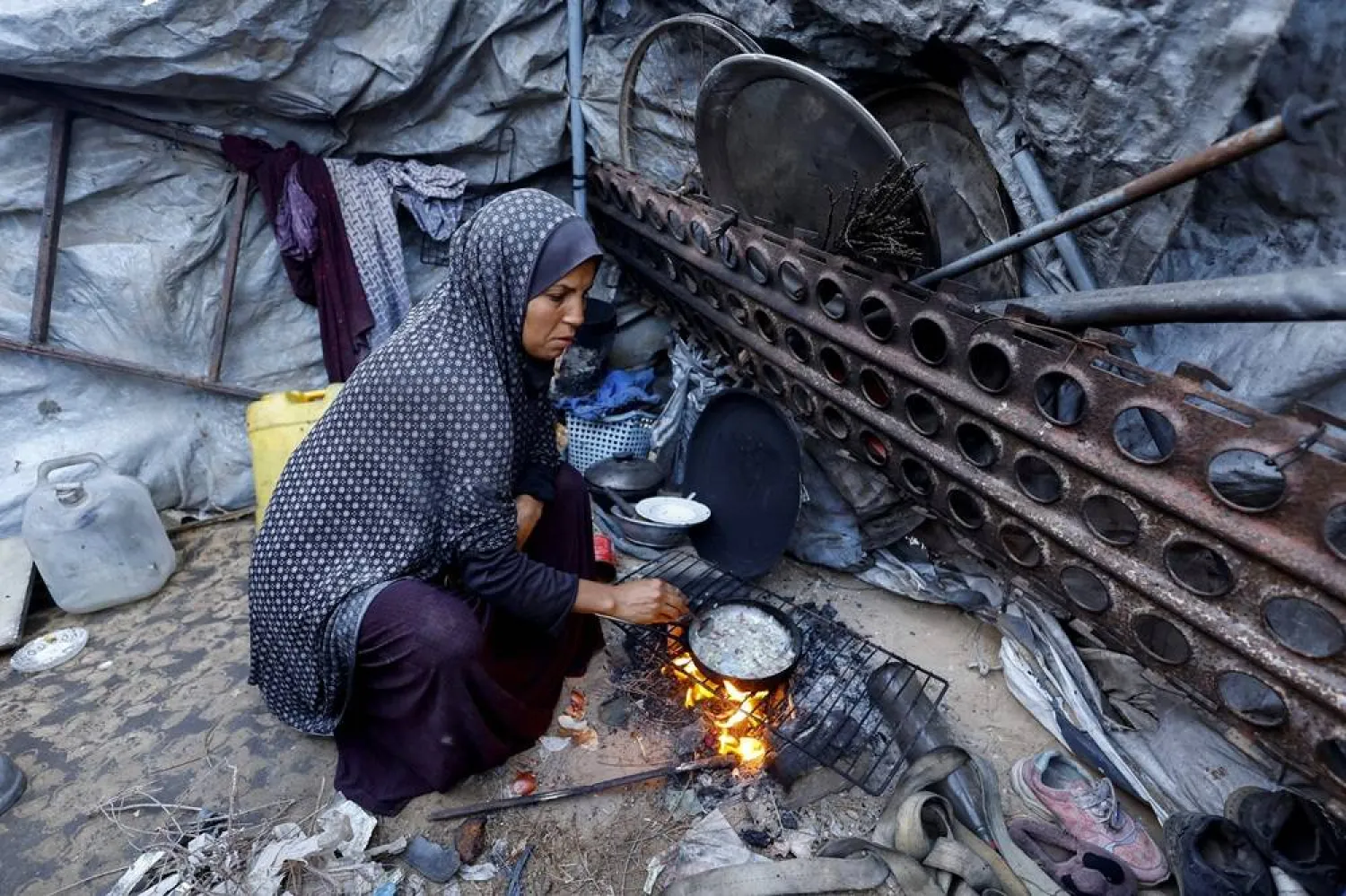  A displaced Palestinian woman cooks on a fire at her tent, amid a ceasefire between Israel and Hamas, in Gaza City, November 4, 2025. (Reuters)