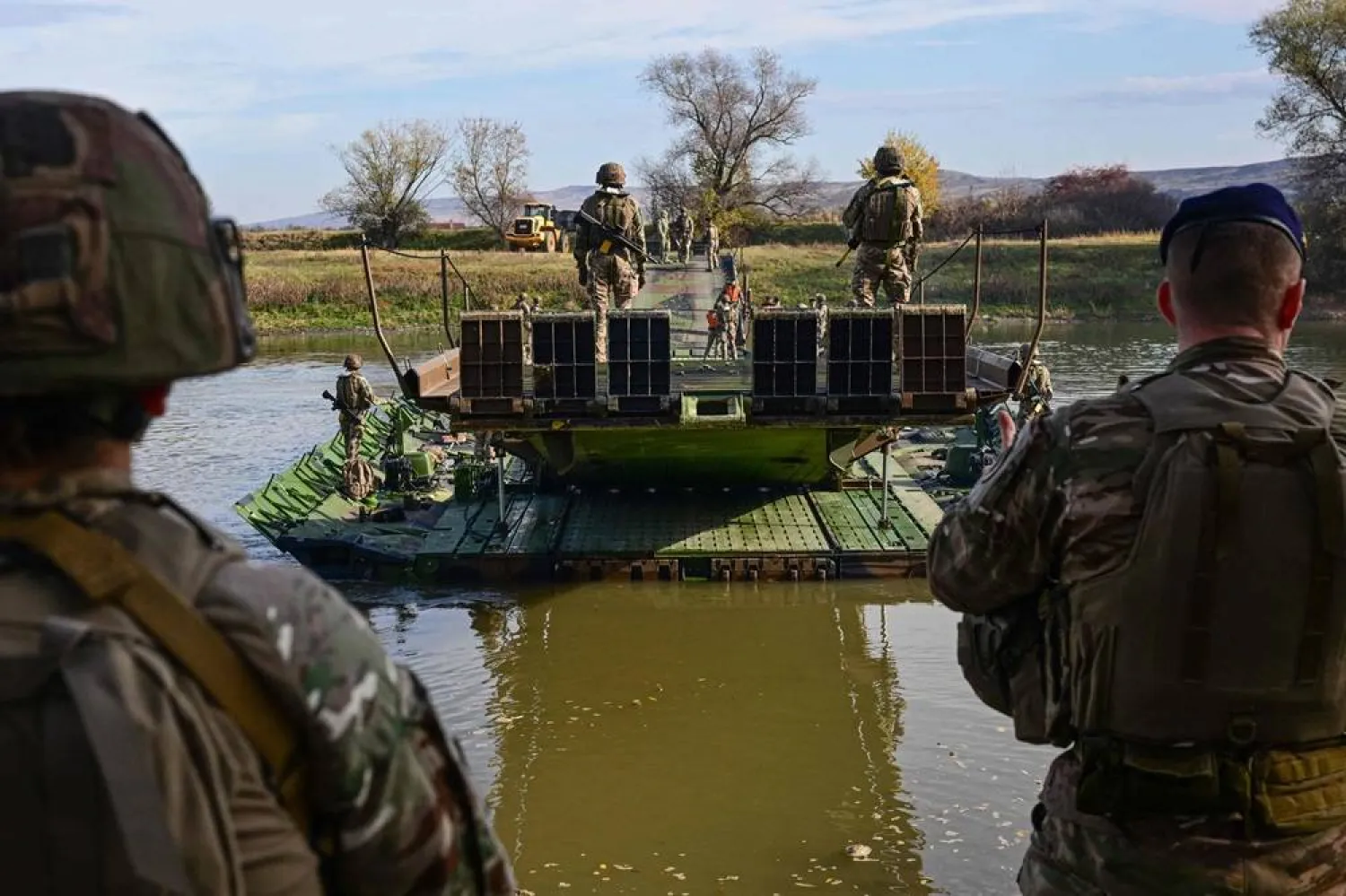 France's Army personnel from the combat engineering corps maneuver a motorized floating bridge (PFM) across the Mures River during the "Dacian Fall" military exercise in Santimbru on November 3, 2025. (AFP) 