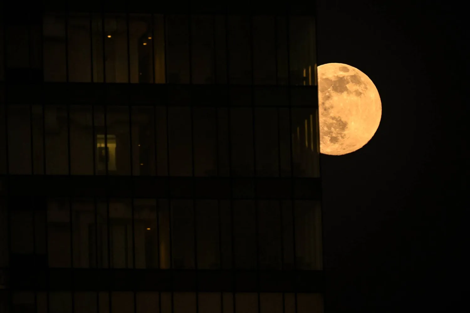 The supermoon known as the Beaver Moon is seen behind an office building in Mexico City on November 4, 2025. (AFP)