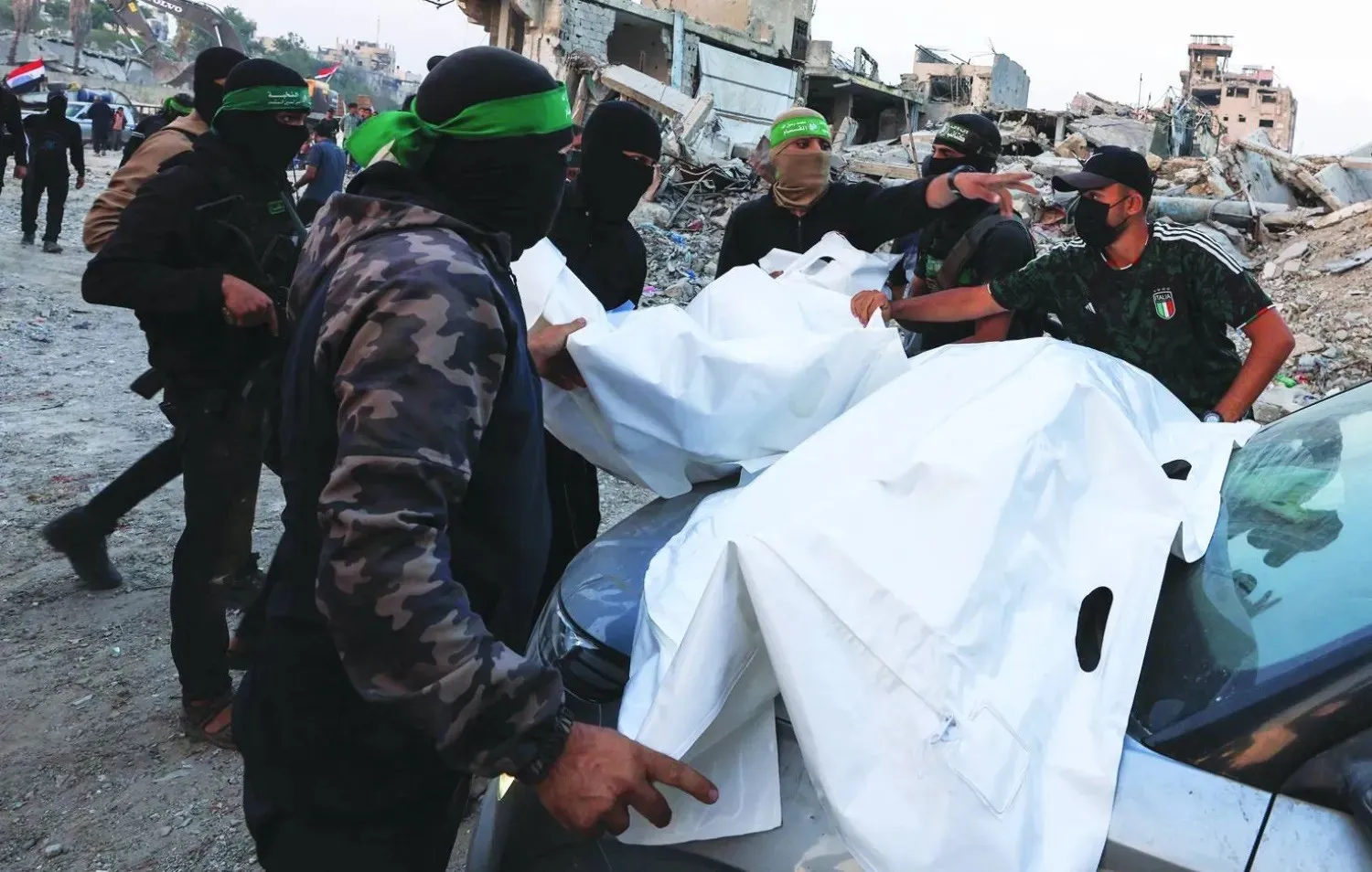 Hamas fighters carry bodies after the group said it found the body of an Israeli soldier and was preparing to return it to Israel, in Gaza City. (Reuters)