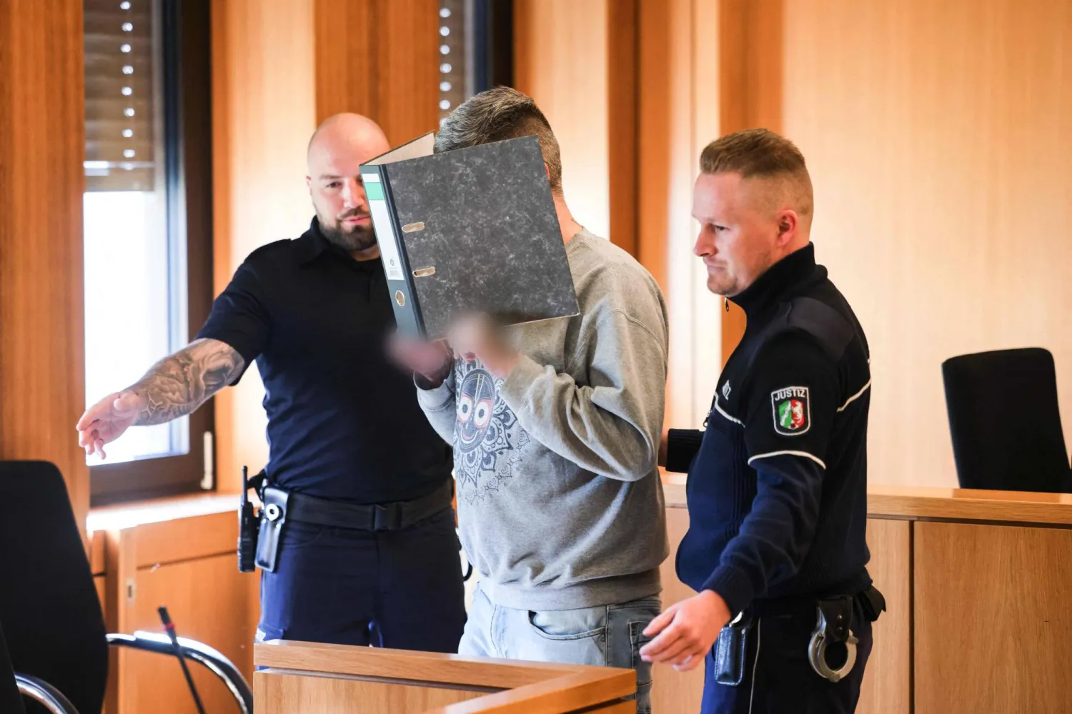 الممرض السابق يُخفي وجهه أثناء محاكمته (د.ب.أ)