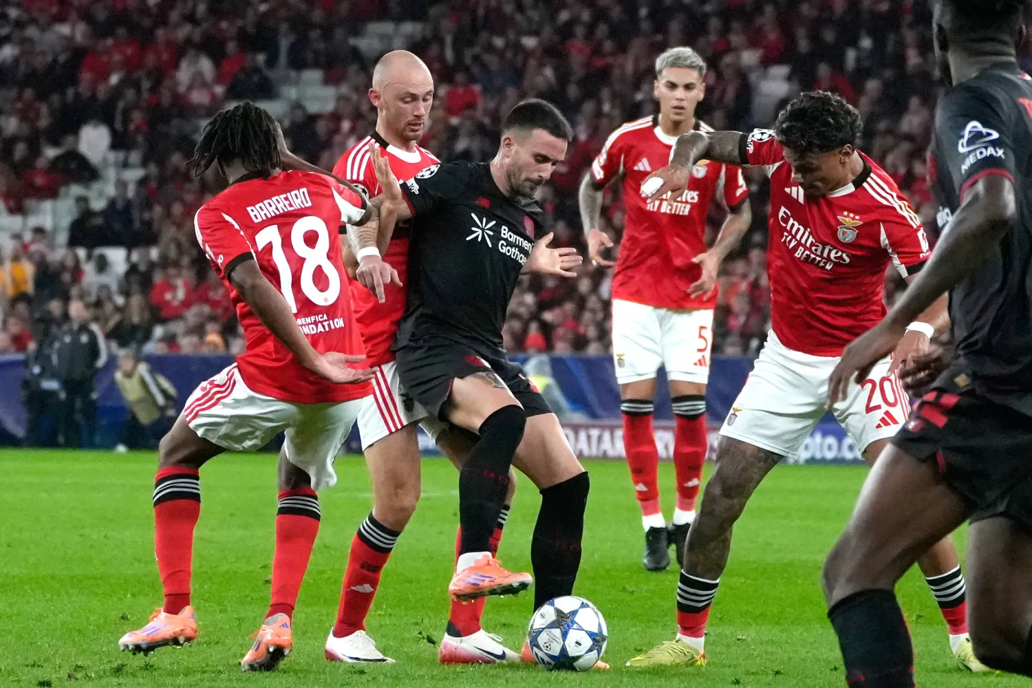 لاعب باير ليفركوزن أليكس غارسيا يحافظ على الكرة تحت ضغط من لاعب بنفيكا أورسنيس (أ.ب).