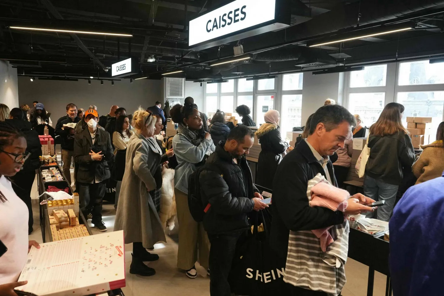 Costumers shops on the opening day of Asian e-commerce giant Shein's first physical store at the Bazar de l'Hotel de Ville (BHV) department store in Paris on November 5, 2025. (Photo by Dimitar DILKOFF / AFP)