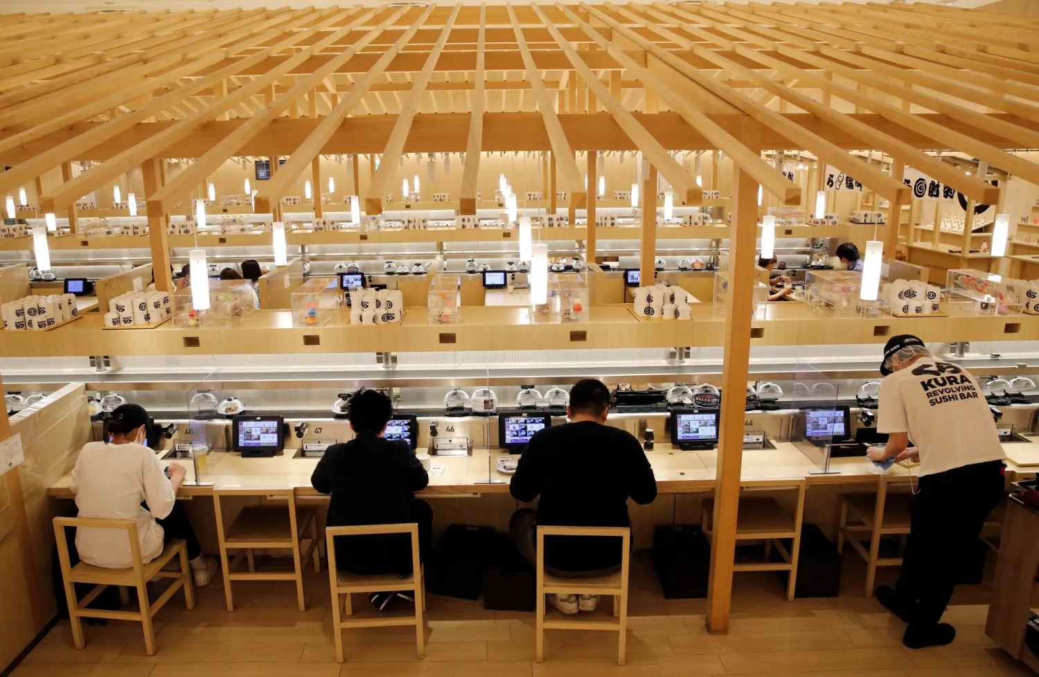 يتناول الزبائن السوشي في مطعم «كورا سوشي» بطوكيو (رويترز)