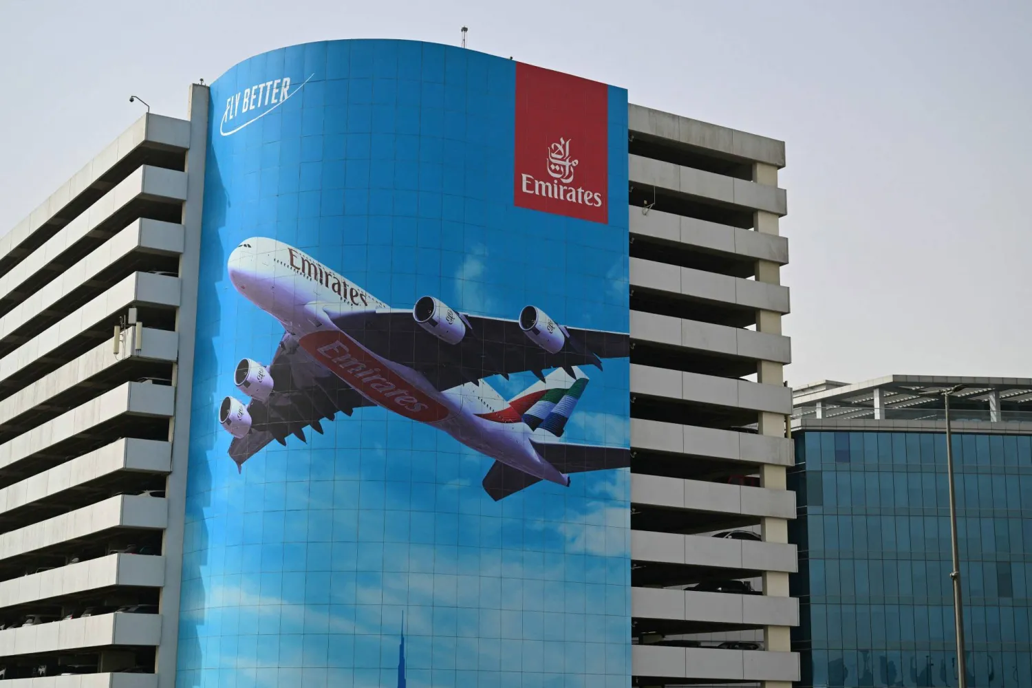 A billboard advertising the national flag carrier of the United Arab Emirates, Emirates Airways, hangs from a building near Dubai International Airport, in Dubai on November 6, 2025. (Photo by Giuseppe CACACE / AFP)