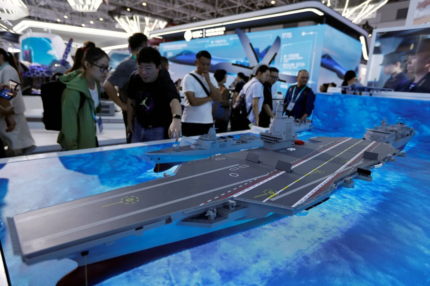 FILE PHOTO: Visitors look at a model of the Fujian aircraft carrier displayed at the China International Aviation and Aerospace Exhibition, or Airshow China, in Zhuhai, Guangdong province, China November 14, 2024. REUTERS/Tingshu Wang/File Photo