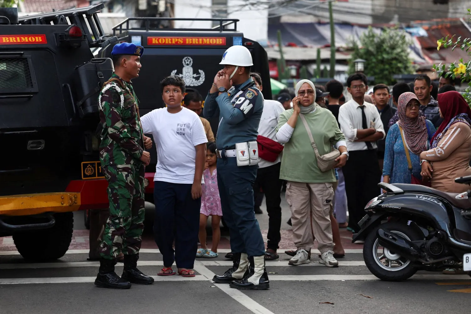 Indonesian military personnel guard as residents gather near the area after an explosion occurred at a school complex in Jakarta, Indonesia, November 7, 2025. REUTERS/Willy Kurniawan
