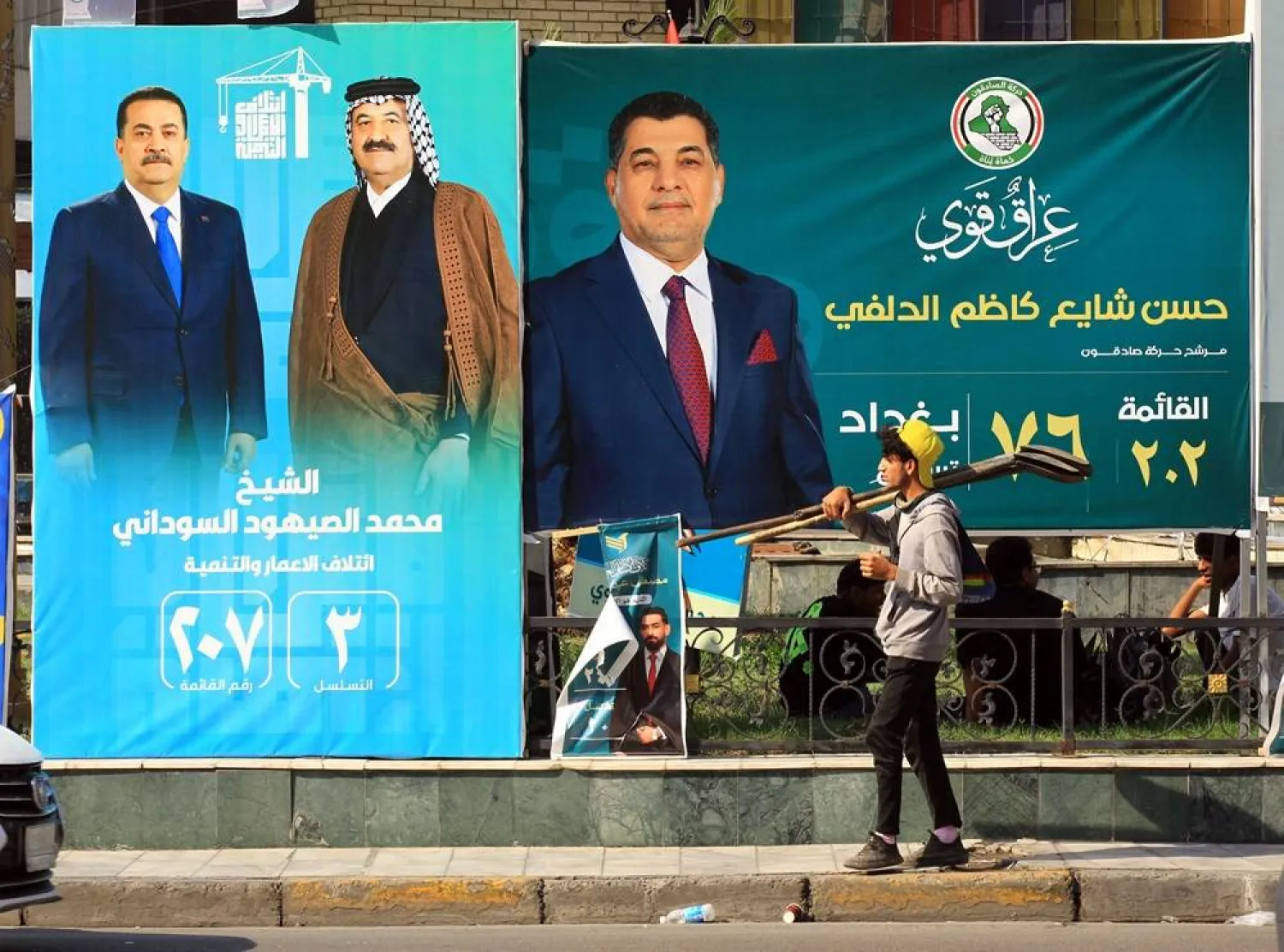 A young Iraqi worker walks past election campaigning posters ahead of the parliamentary elections in Baghdad, Iraq, 07 November 2025. (EPA)