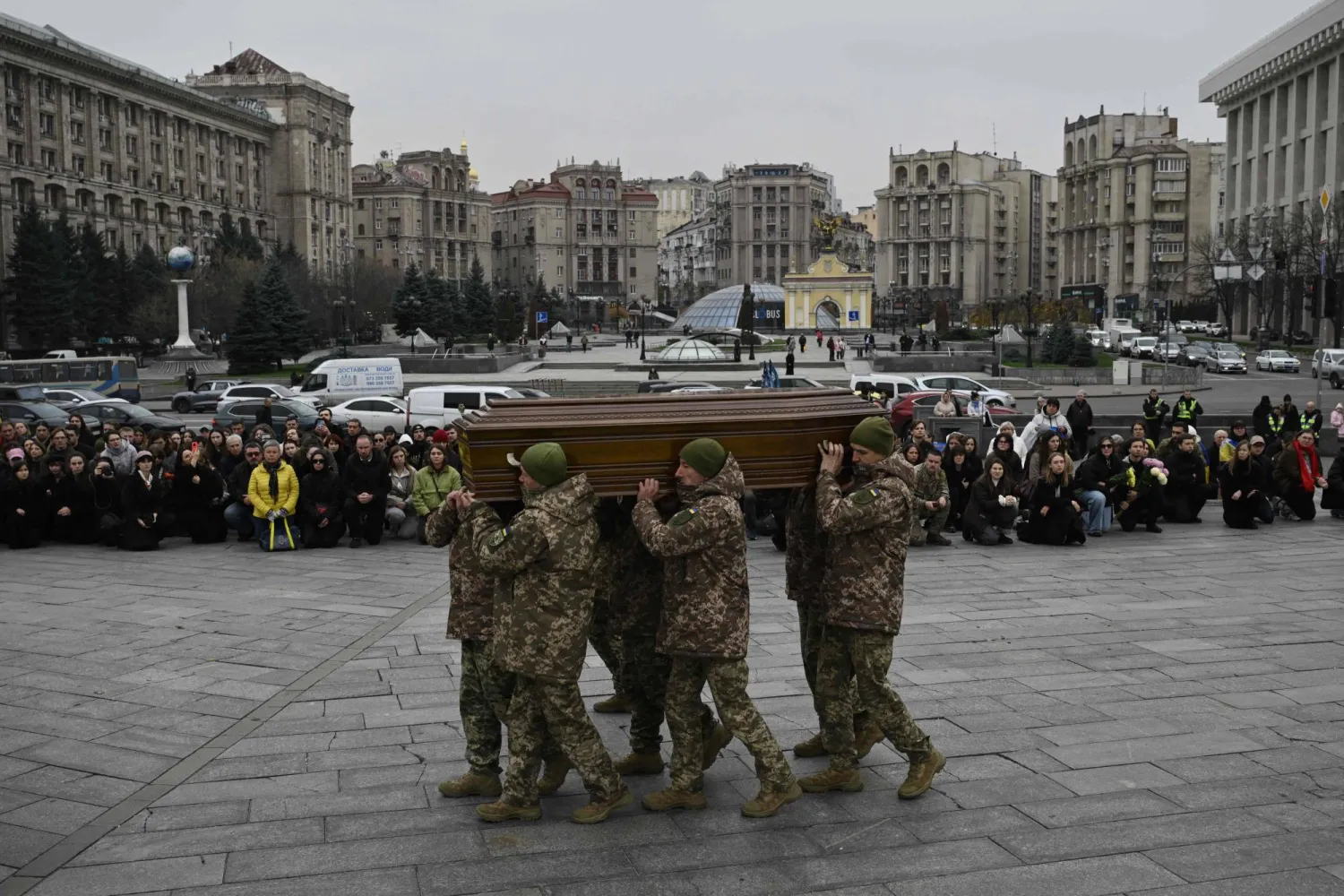  جنود من حرس الشرف يحملون نعش الجندي الأوكراني (أ.ف.ب)