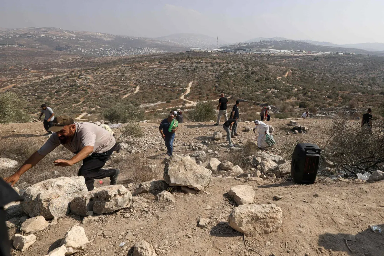 İşgal altındaki Batı Şeria'da, Nablus'un doğusunda yerleşimcilerin topraklarına el koymasını protesto eden Filistinliler, dün İsrail ordusunun attığı gaz bombalarından kaçıyor (AFP)