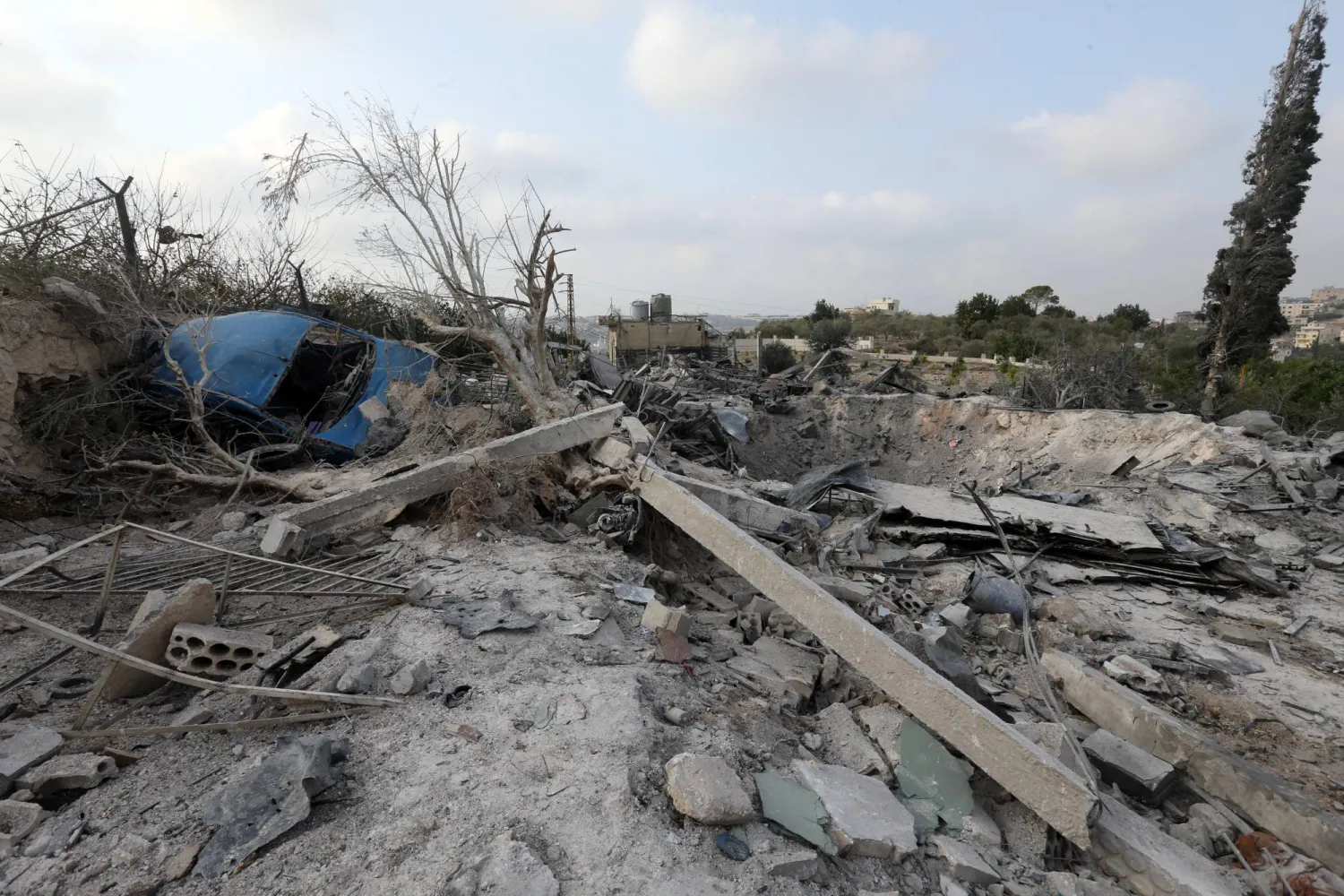 سيارة متضررة ملقاة وسط الأنقاض تظهر في موقع استهدفه الجيش الإسرائيلي بقضاء صور بجنوب لبنان (إ.ب.أ)