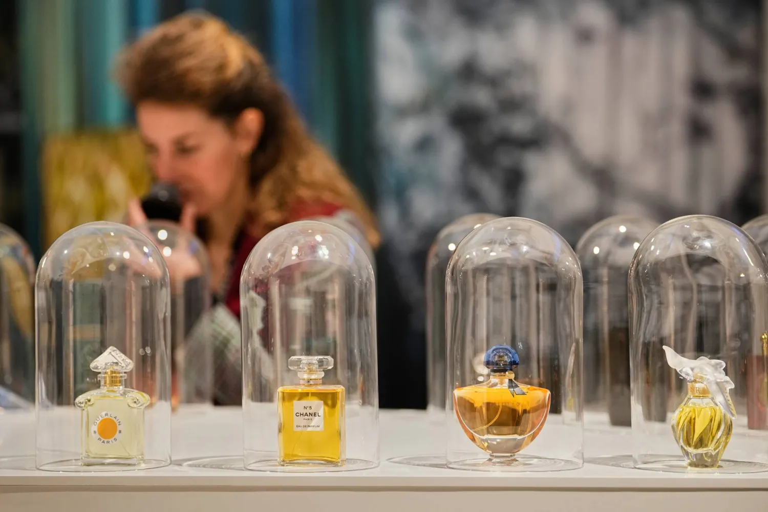 A woman smells samples of famous perfumes during the exhibition "The Secret Power of Scents", showing the history of scent from antiquity to the present as a sensory experience at the Kunstpalast art museum in Duesseldorf, Germany, Tuesday, Oct. 28, 2025. (AP Photo/Martin Meissner)