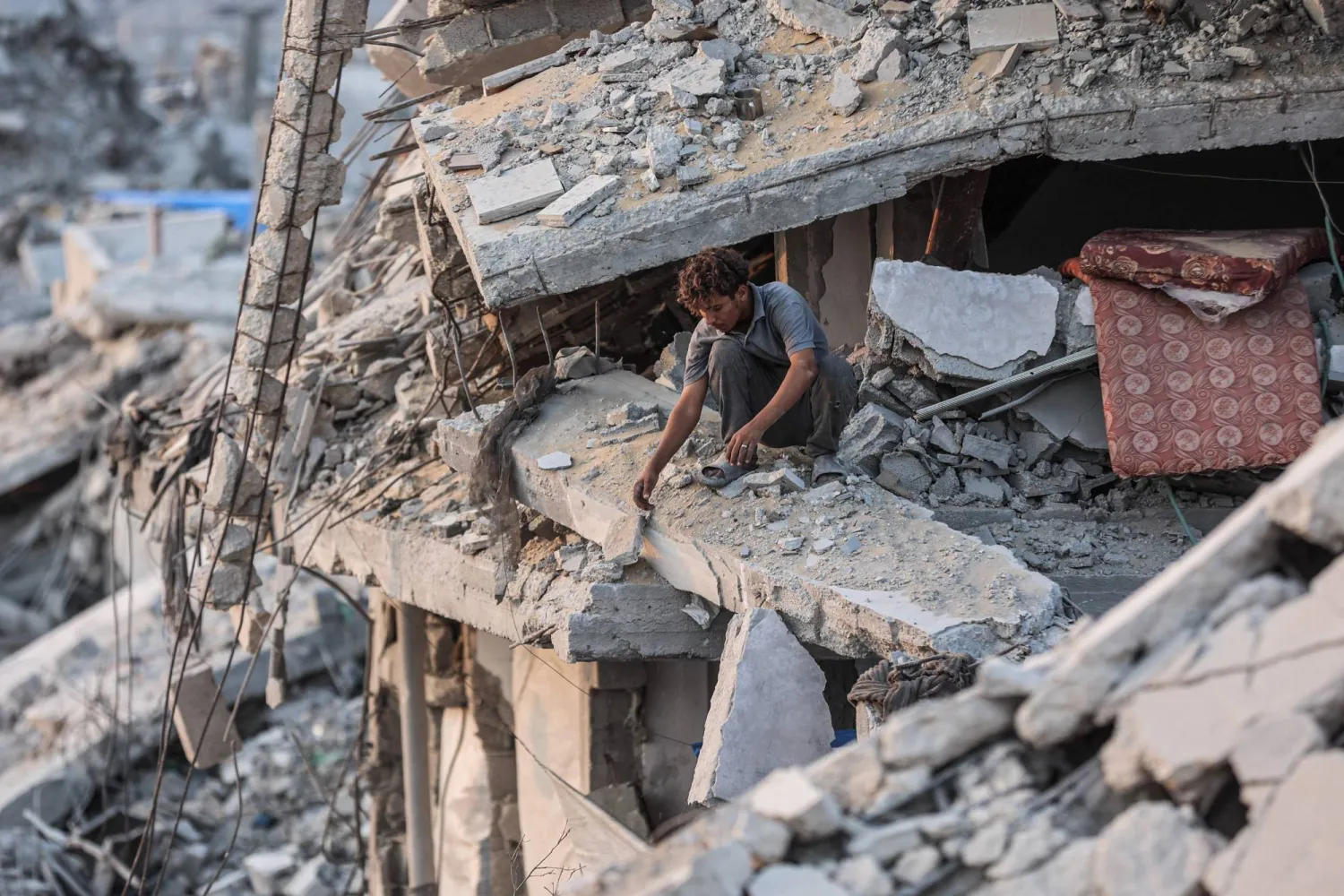 A Palestinian man sits on the rubble of a destroyed building in Jabalia, in the northern Gaza Strip, on November 7, 2025. (Photo by Omar AL-QATTAA / AFP)