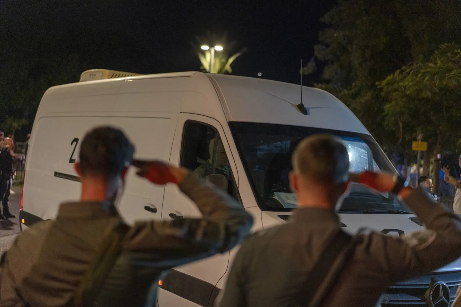 جنديان إسرائيليان يؤديان التحية لعربة تنقل جثث رهائن أعيدت من قطاع غزة الشهر الماضي (د.ب.أ)