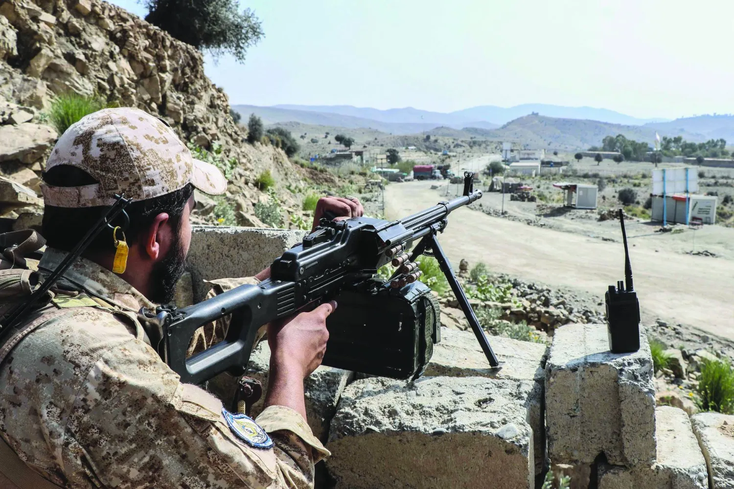 يقف أحد عناصر أمن «طالبان» حارساً على طريق قرب معبر غلام خان الحدودي بين أفغانستان وباكستان (أ.ف.ب)