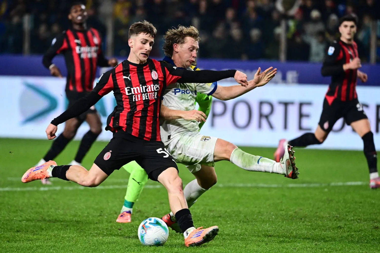 البلجيكي أليكسيس سايليماكرز لاعب ميلان يتنافس على الكرة مع الدنماركي أوليفر سورينسن لاعب بارما (أ.ف.ب).