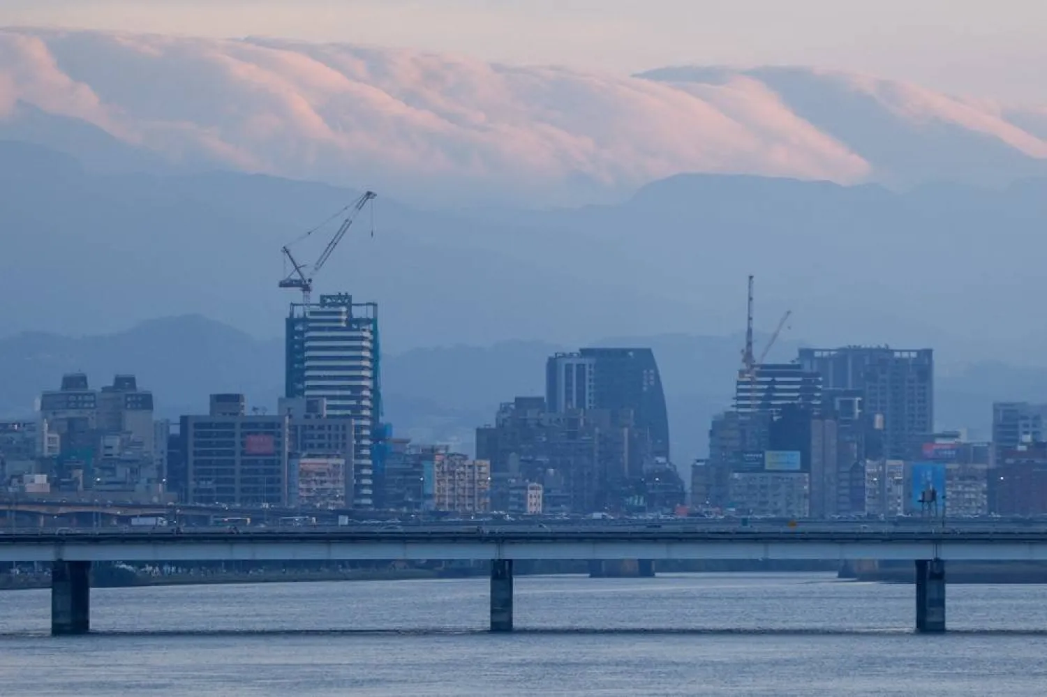 A view of the Taipei skyline with clouds hanging over distant mountains, seen from across the Tamsui River in Taipei, Taiwan, November 8, 2025. (Reuters)