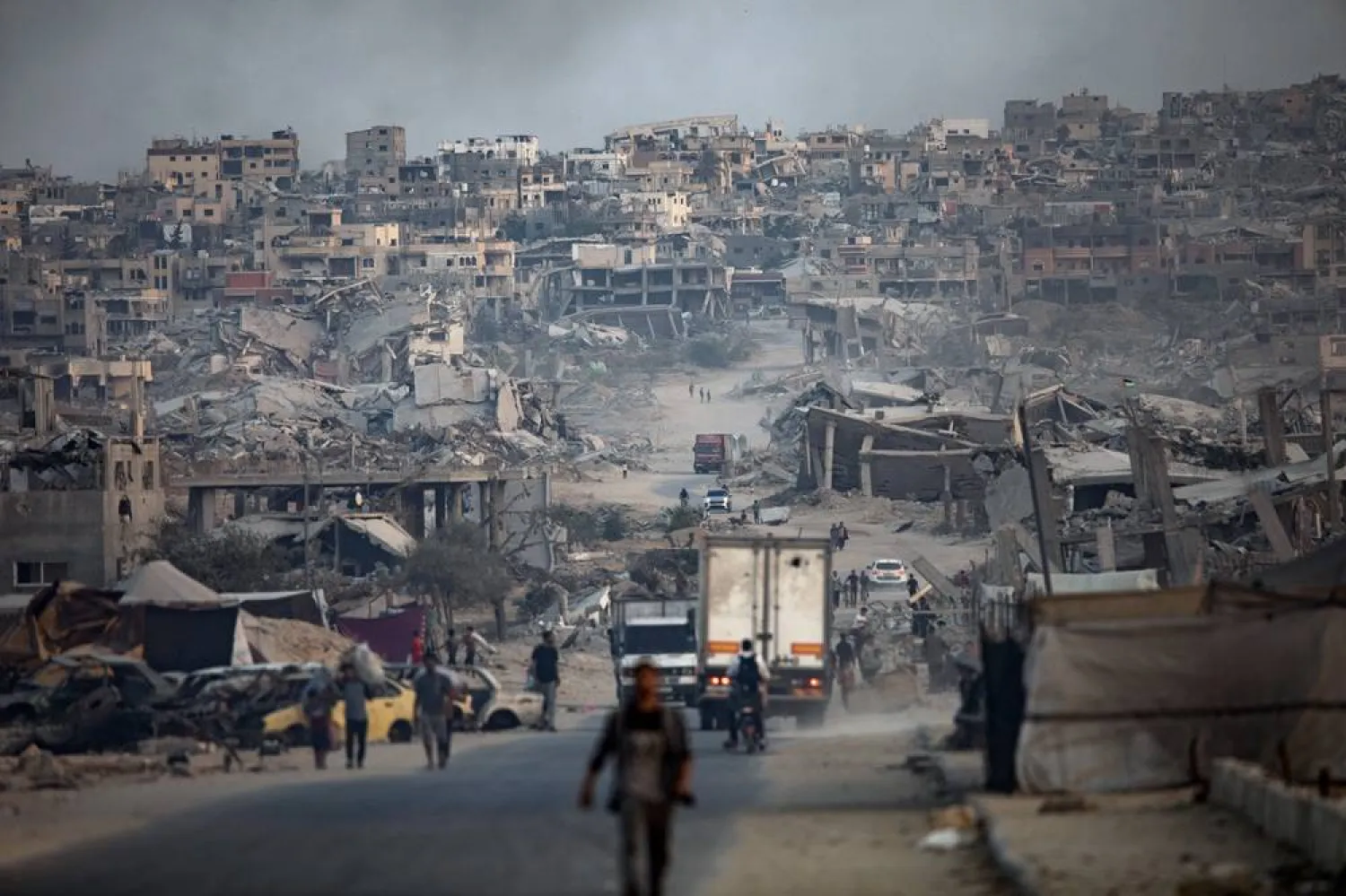 Displaced Palestinians walk among heavily damaged buildings in Khan Younis refugee camp, southern Gaza Strip, 08 November 2025. (EPA)