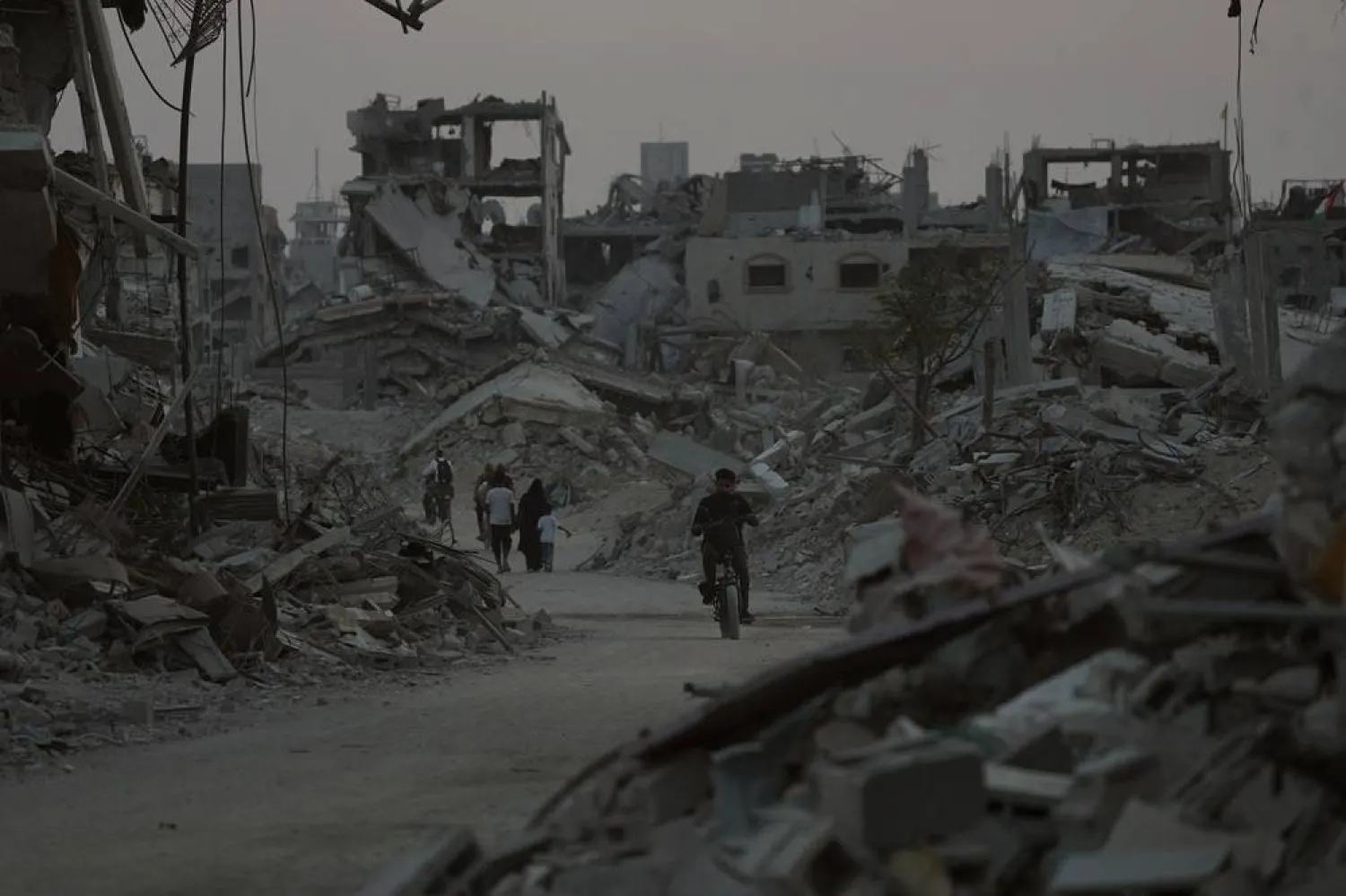  Displaced Palestinians walk among the ruins of destroyed buildings in Khan Younis, Gaza Strip, Saturday, Nov. 8, 2025. (AP)
