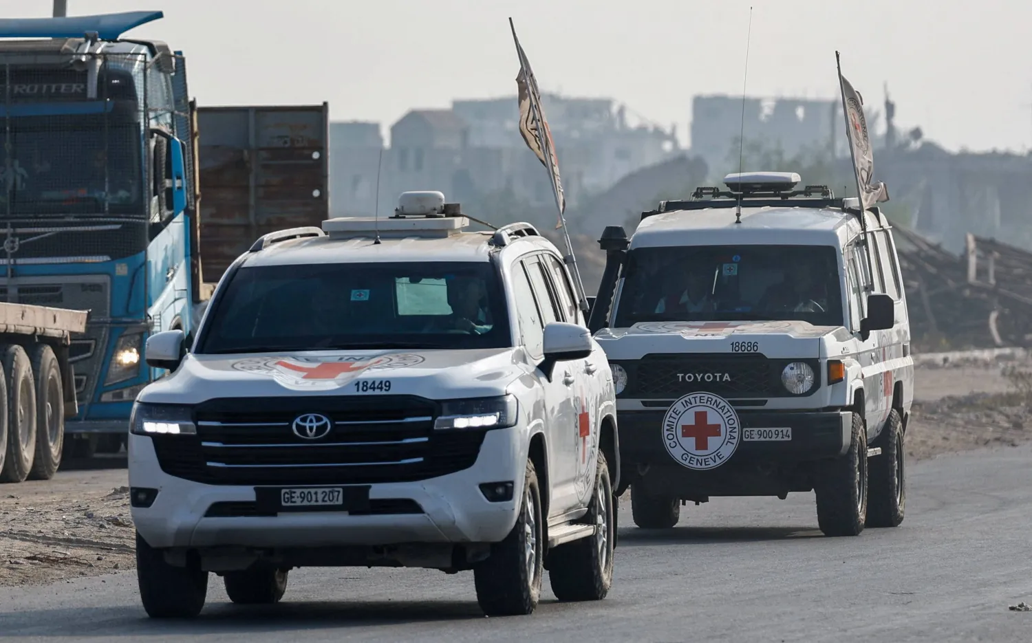 سيارات الصليب الأحمر تنقل رفات الضابط الإسرائيلي هدار غولدن في دير البلح بوسط قطاع غزة يوم الأحد (رويترز)