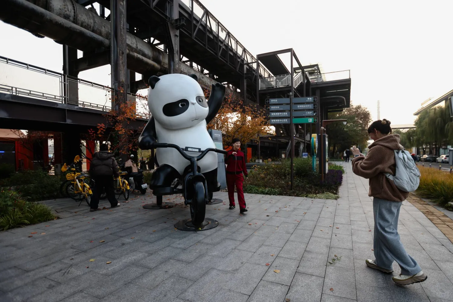 A woman poses for a photo beside a Panda statue at Shougang Park in Beijing, China, 08 November 2025. EPA/WU HAO