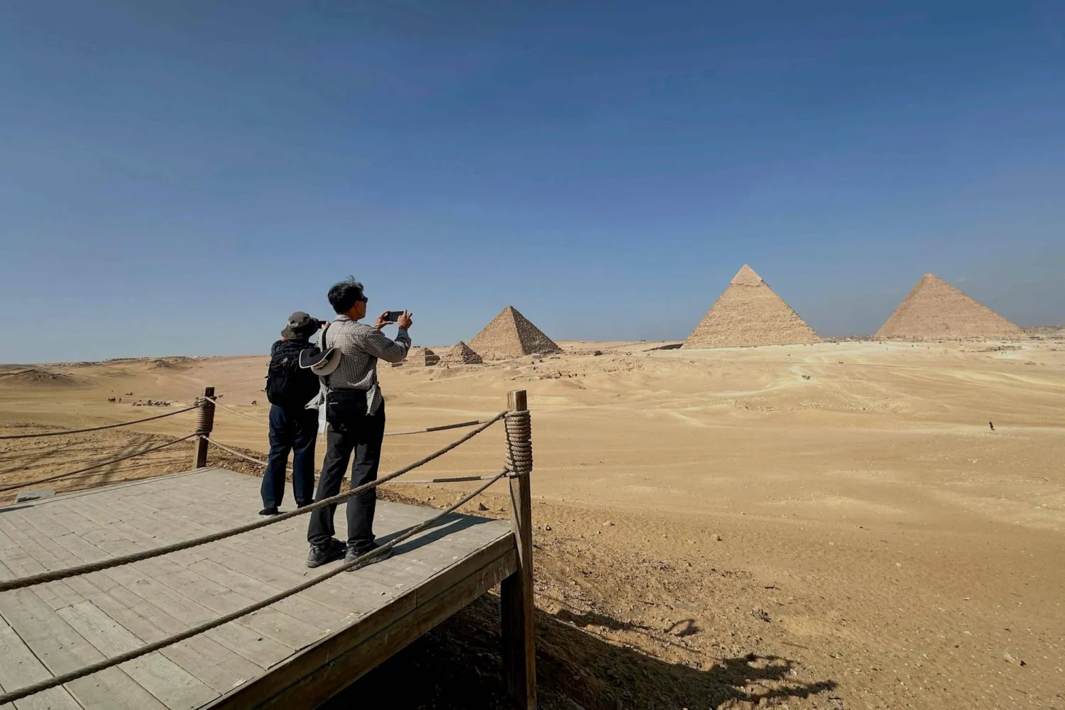 سائح يلتقط صورة لأهرامات الجيزة على المشارف الجنوبية الغربية للقاهرة (أ.ف.ب)