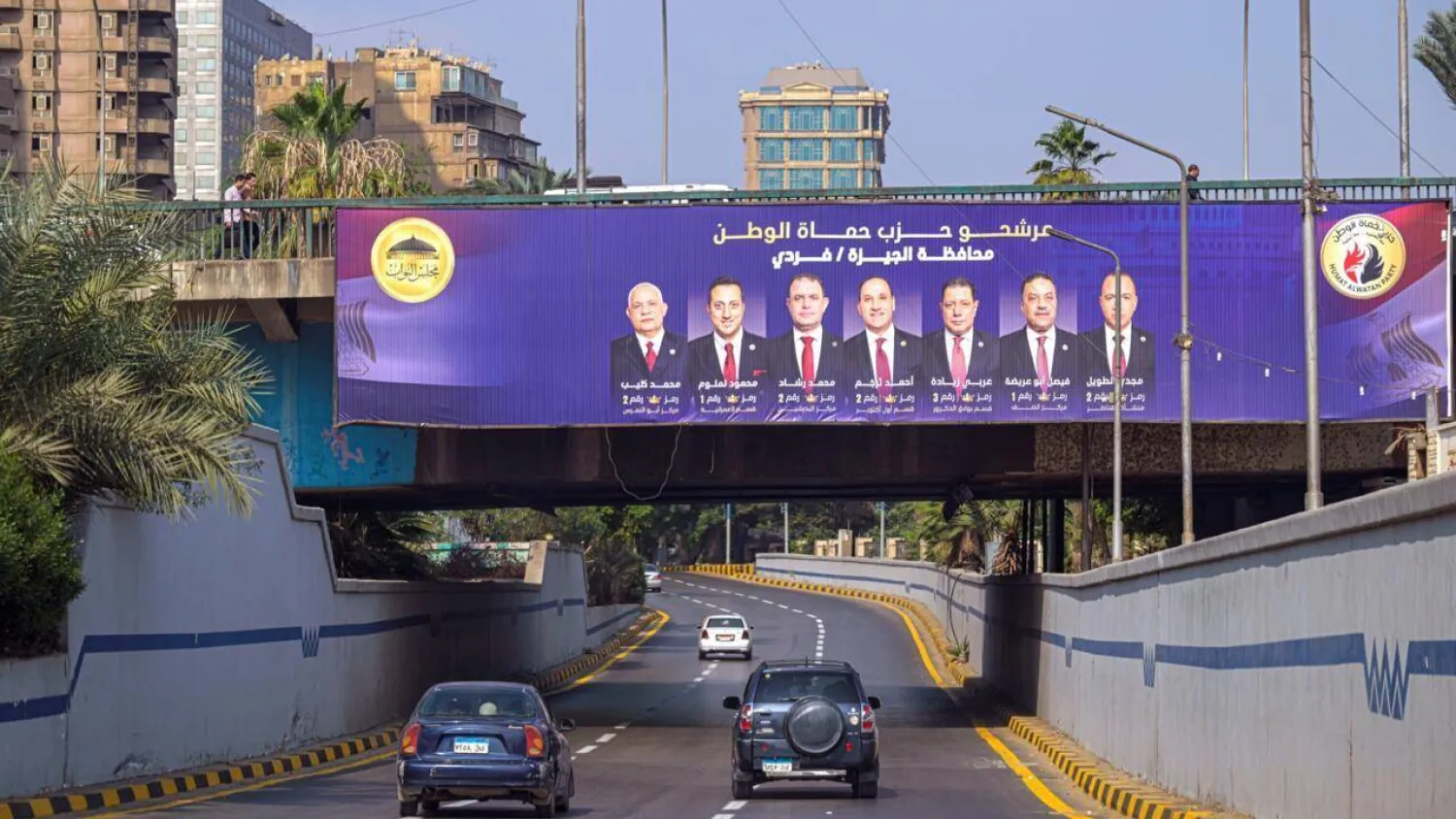 Motorists drive past a campaign billboard in Giza for the Egyptian parliamentary elections. Khaled DESOUKI / AFP
