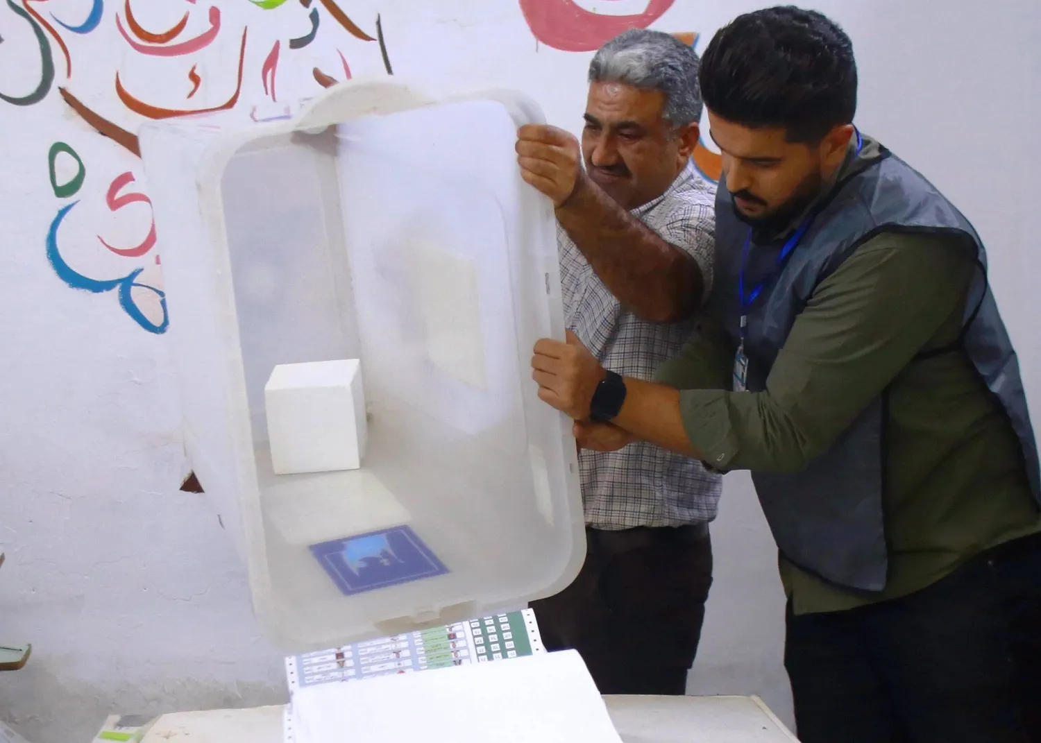 موظفون من «مفوضية الانتخابات» العراقية يفرزون أوراق الاقتراع بعد يوم التصويت الخاص في الانتخابات البرلمانية ببغداد (إ.ب.أ)