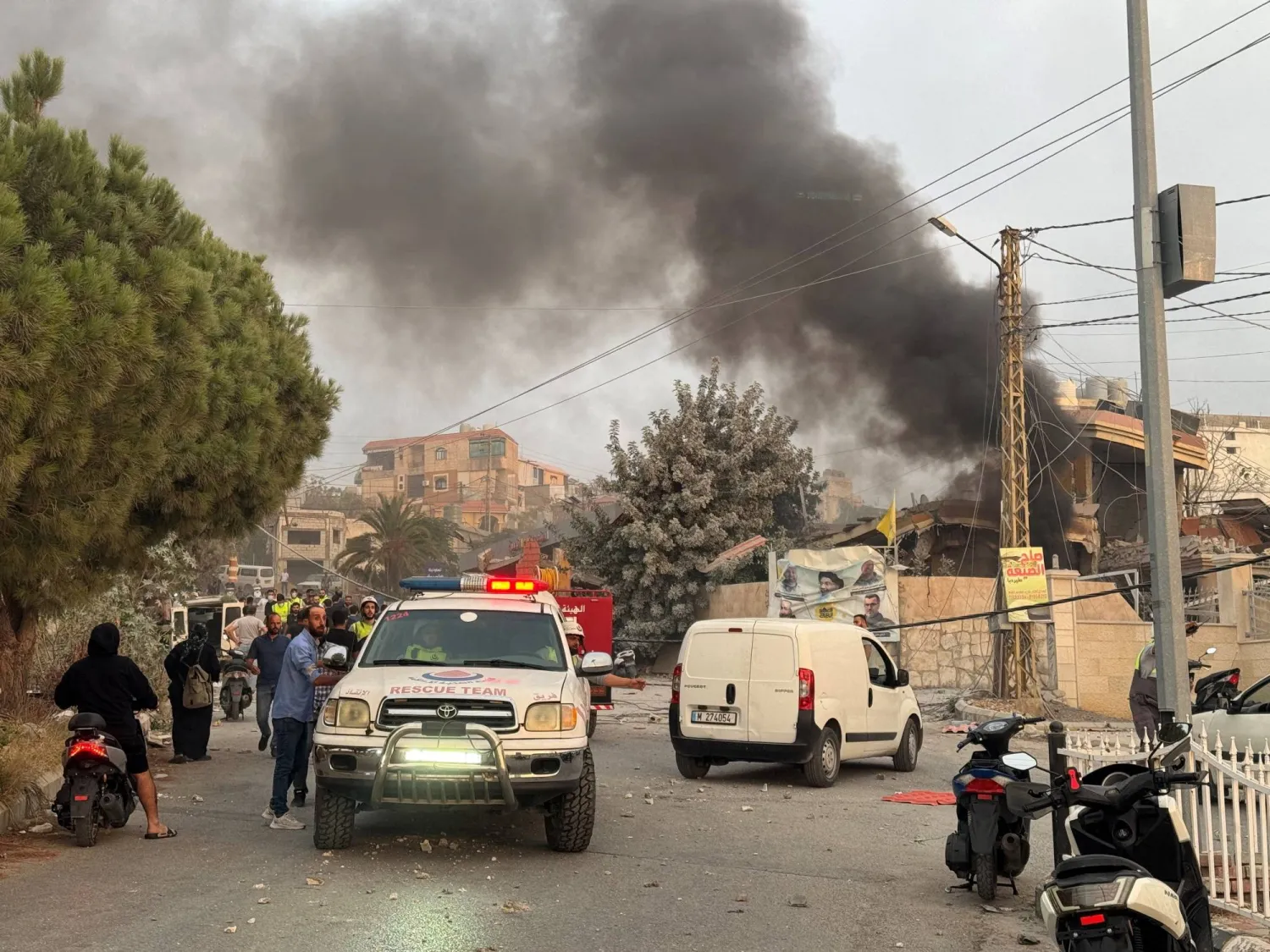 FILE PHOTO: People gather as smoke rises after Israeli strikes following Israeli military's evacuation orders, in Tayr Debba, southern Lebanon November 6, 2025. REUTERS/Ali Hankir/File Photo