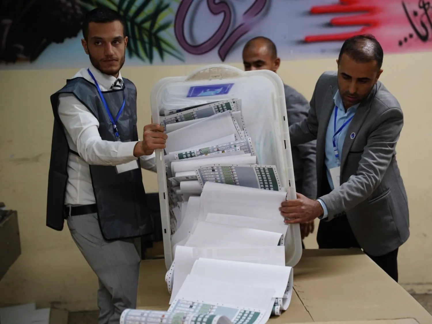 موظفون من «مفوضية الانتخابات» العراقية يفرزون أوراق الاقتراع بعد يوم التصويت الخاص في الانتخابات البرلمانية ببغداد (إ.ب.أ)