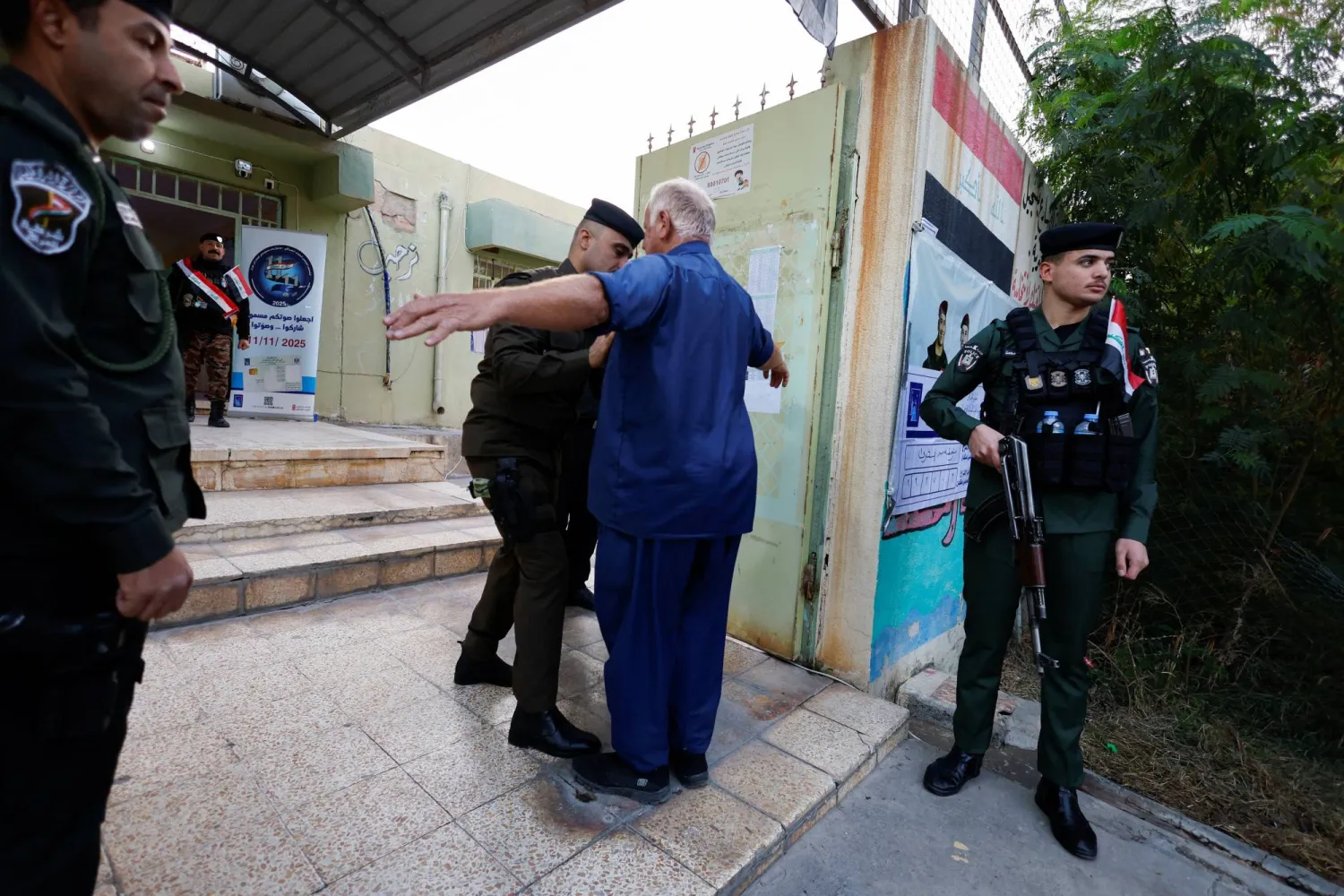 رجال أمن عراقيين يفتشون الناخبين قبل دخولهم مركز اقتراع في الموصل (رويترز)