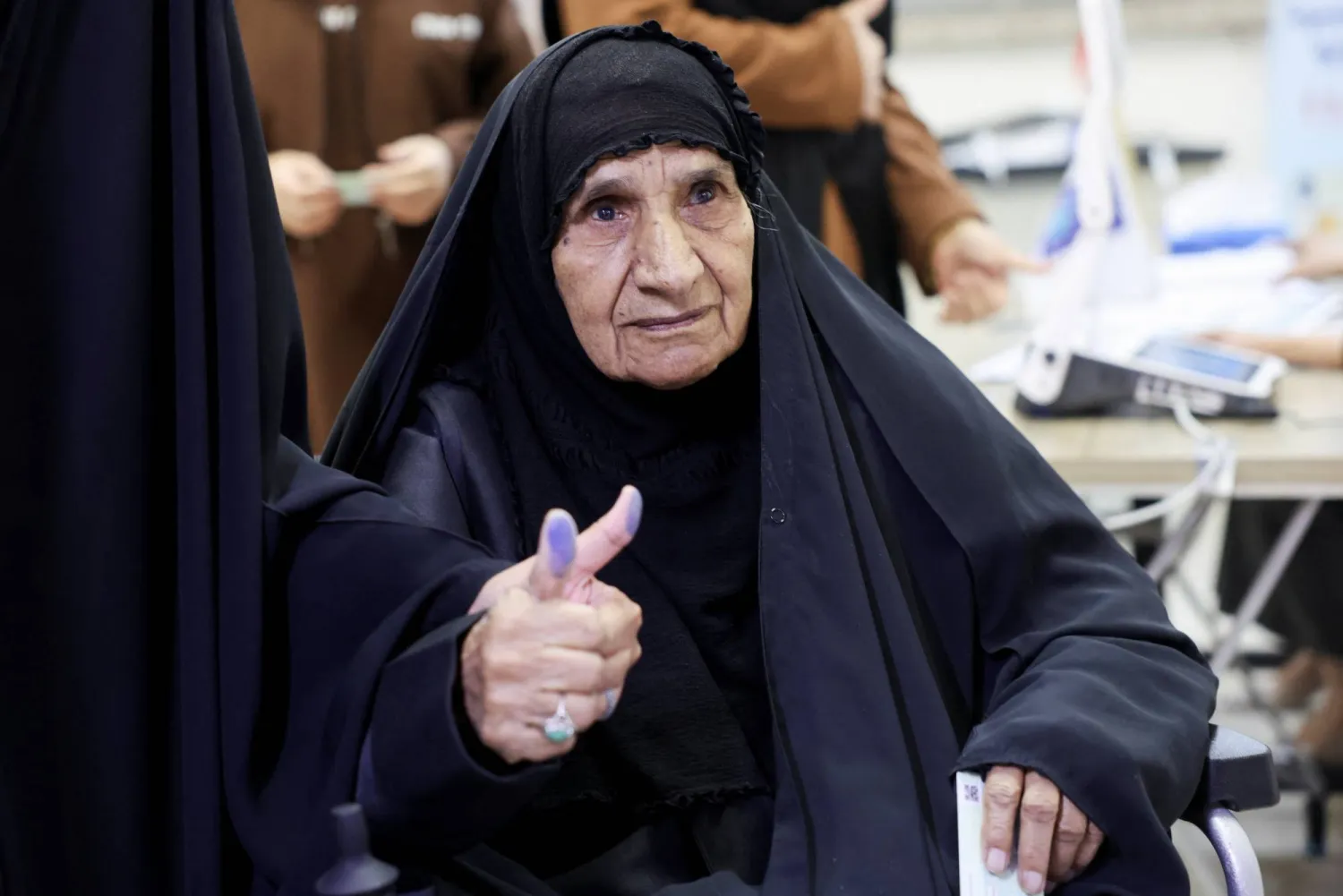 امرأة على كرسي متحرك بعد تصويتها في الانتخابات في بغداد (رويترز)