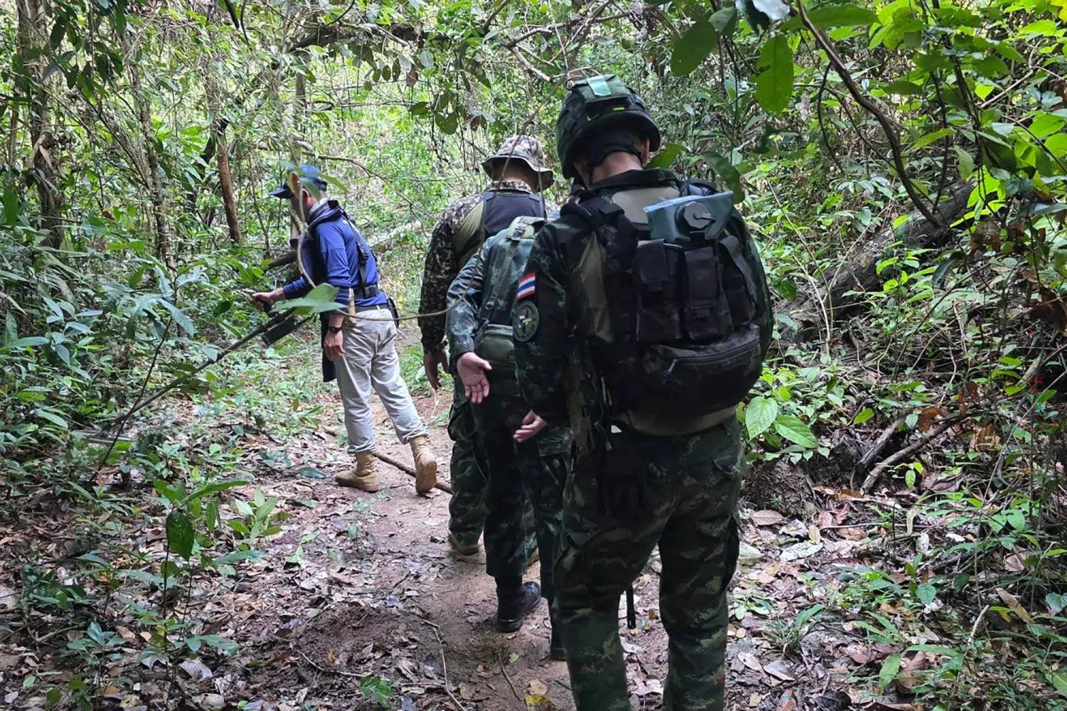 This handout photo taken and released by the Royal Thai Army on November 10, 2025 shows Thai army and police on patrol searching for landmines in Sisasket Province along the Cambodia-Thailand border. (Handout / Royal Thai Army / AFP)