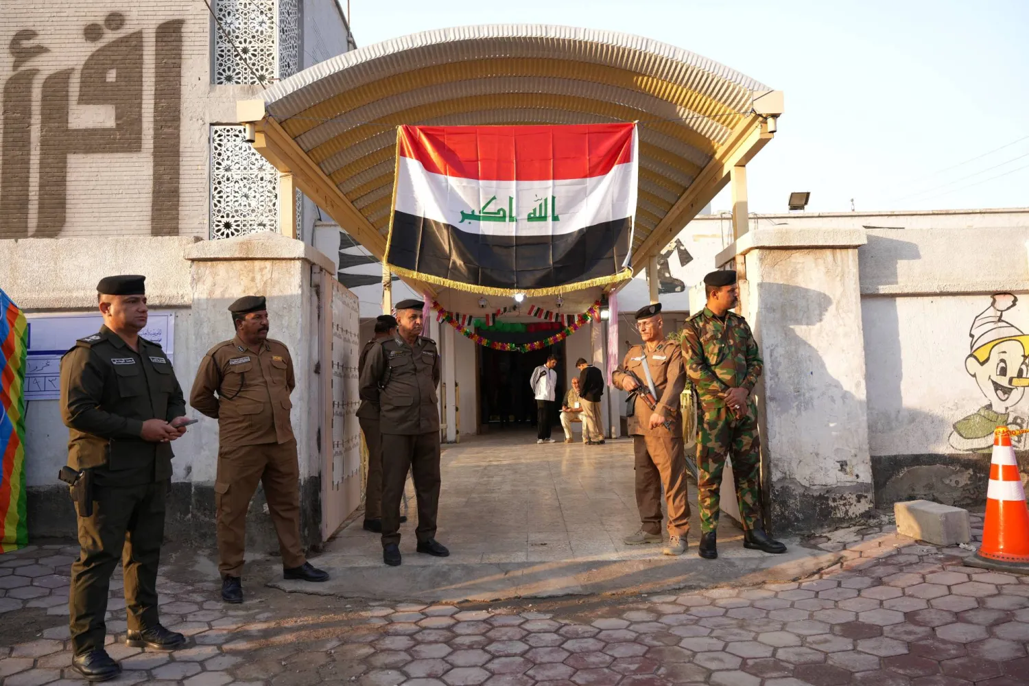 أفراد أمن خارج مركز اقتراع في البصرة (رويترز)