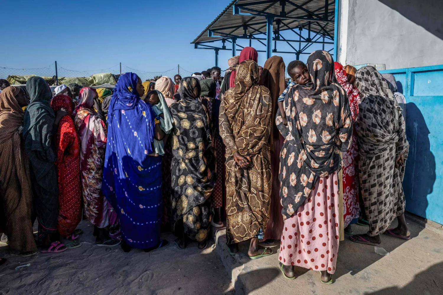 ينتظر اللاجئون السودانيون خارج مكتب تسجيل المفوضية السامية للأمم المتحدة لشؤون اللاجئين في مخيم تين العابر في تشاد