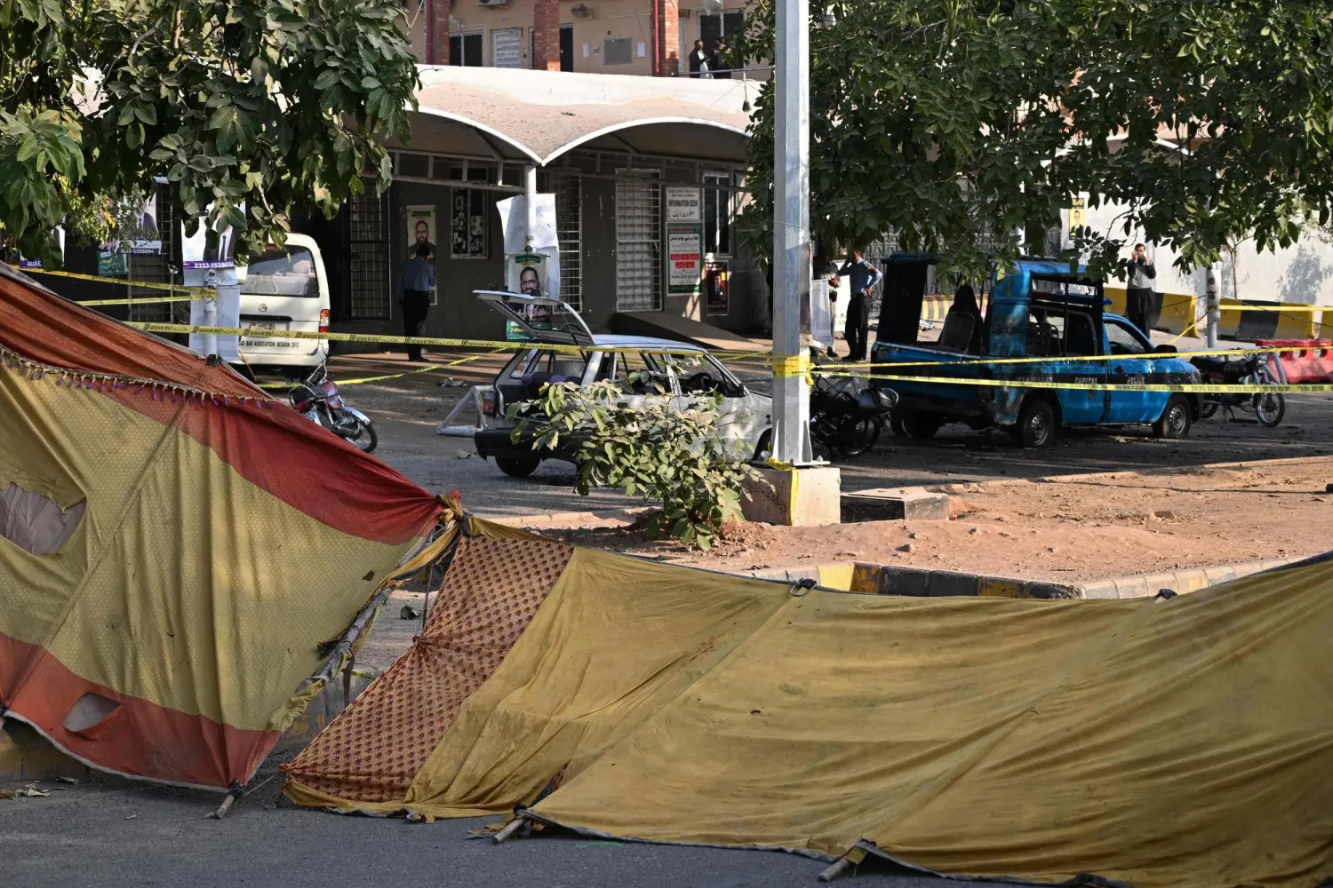 Policemen stand near the wreckage of vehicles at the cordoned-off site, a day after the suicide bombing, in Islamabad on November 12, 2025. (AFP) 