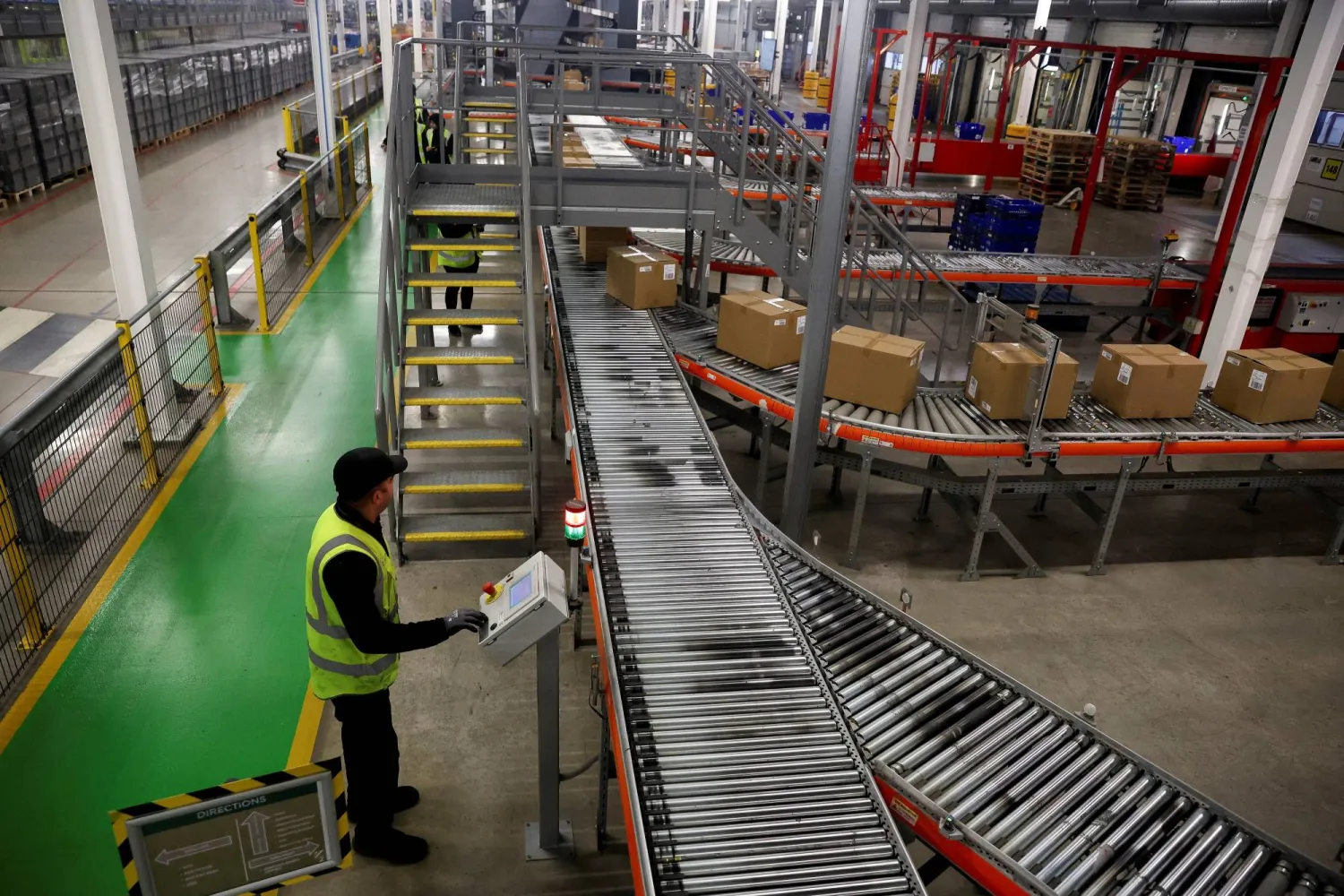 An employee oversees packages being transported on a conveyor belt through the automated sorting facility at a Marks & Spencer (M&S) distribution center in Castle Donington, Leicestershire, Britain, November 7, 2025. REUTERS/Temilade Adelaja